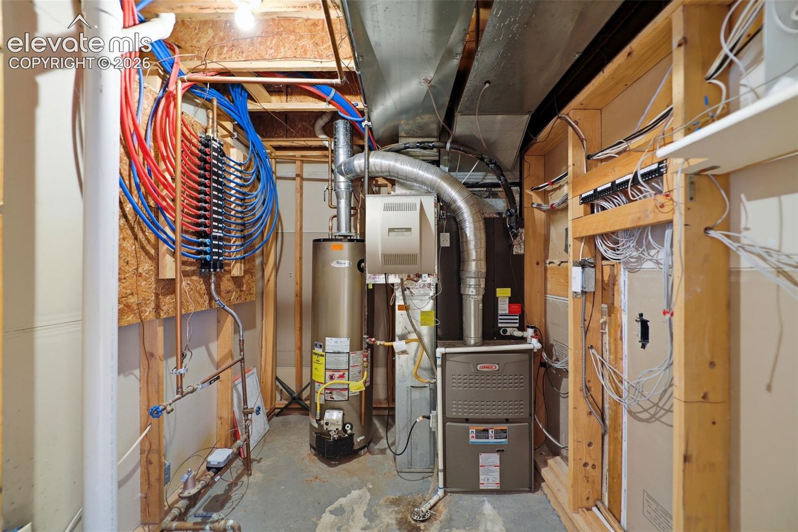 Utility room featuring a water heater, furnace, and comprehensive plumbing and electrical systems