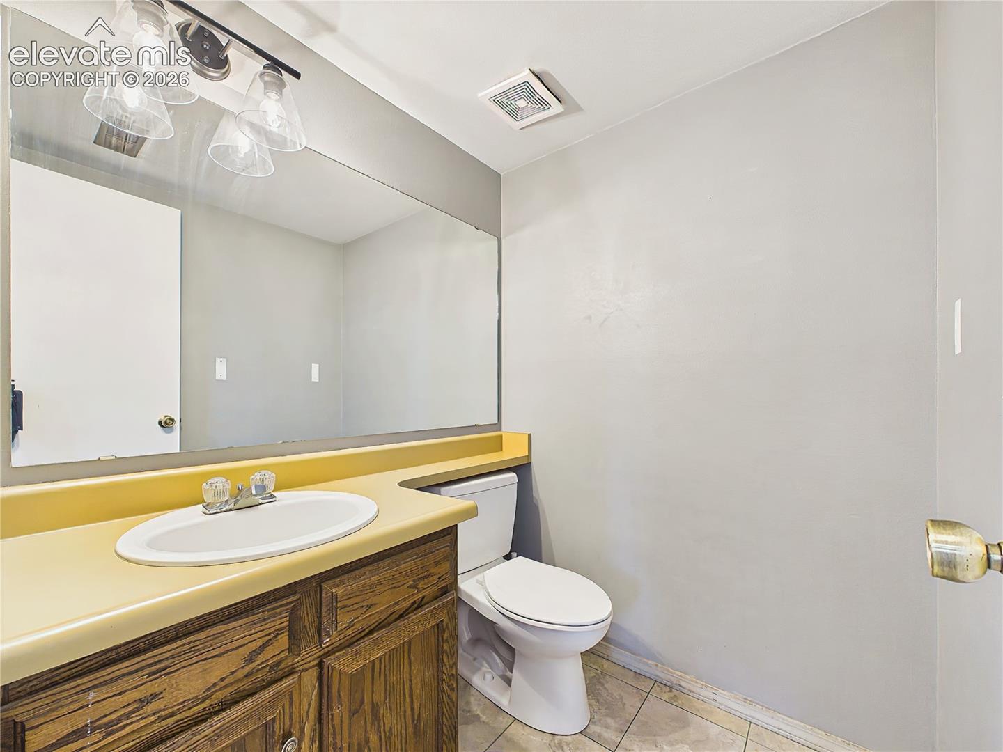 Convenient lower-level half bath with an extended vanity, updated lighting, and easy access to the adjoining living spaces.