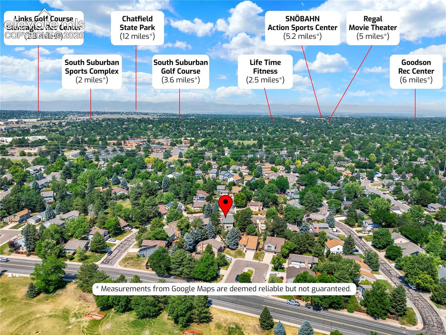 Aerial perspective of the residential area featuring a suburban lot, established tree canopy, and mountain horizon