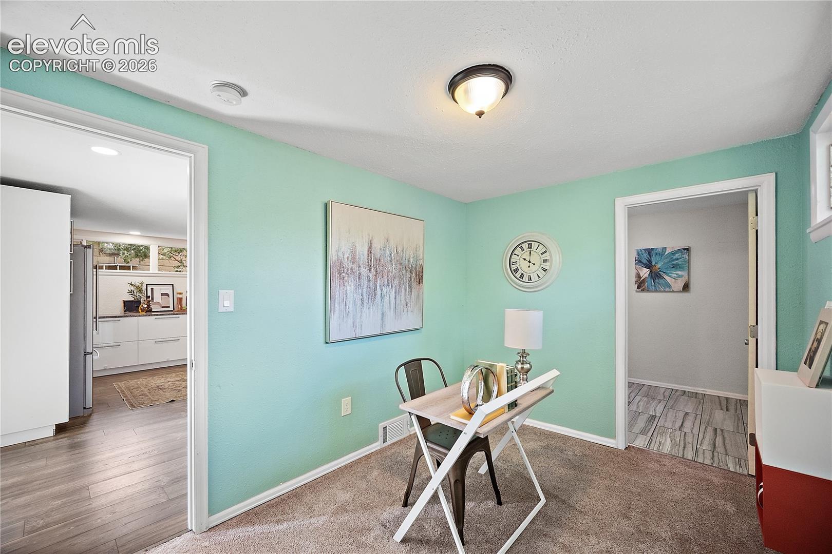 Interior room featuring light teal walls, carpet flooring, and a semi-flush mount ceiling light fixture