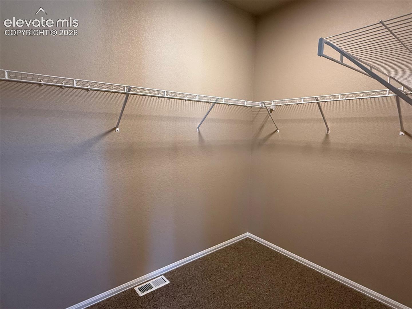 Carpeted closet with white wire shelving