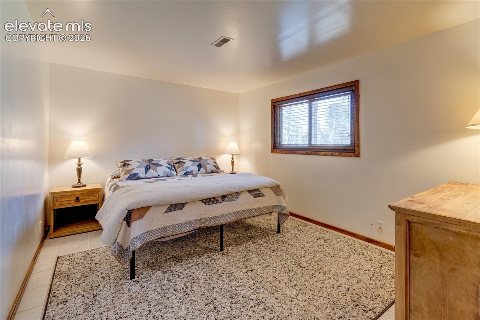 Lower level bedroom with tiled floors