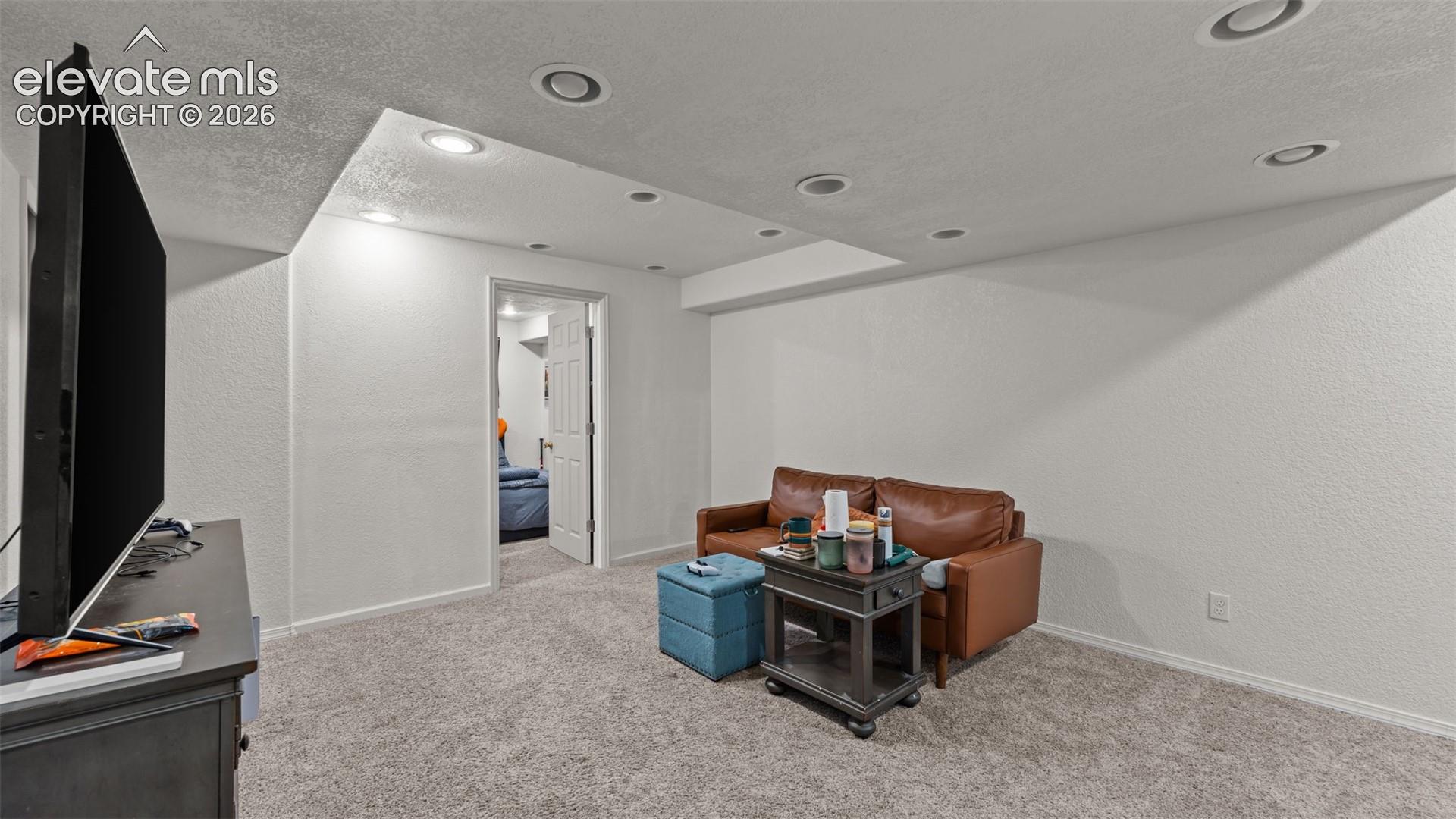 Recessed lighting, light-toned walls, and carpet flooring