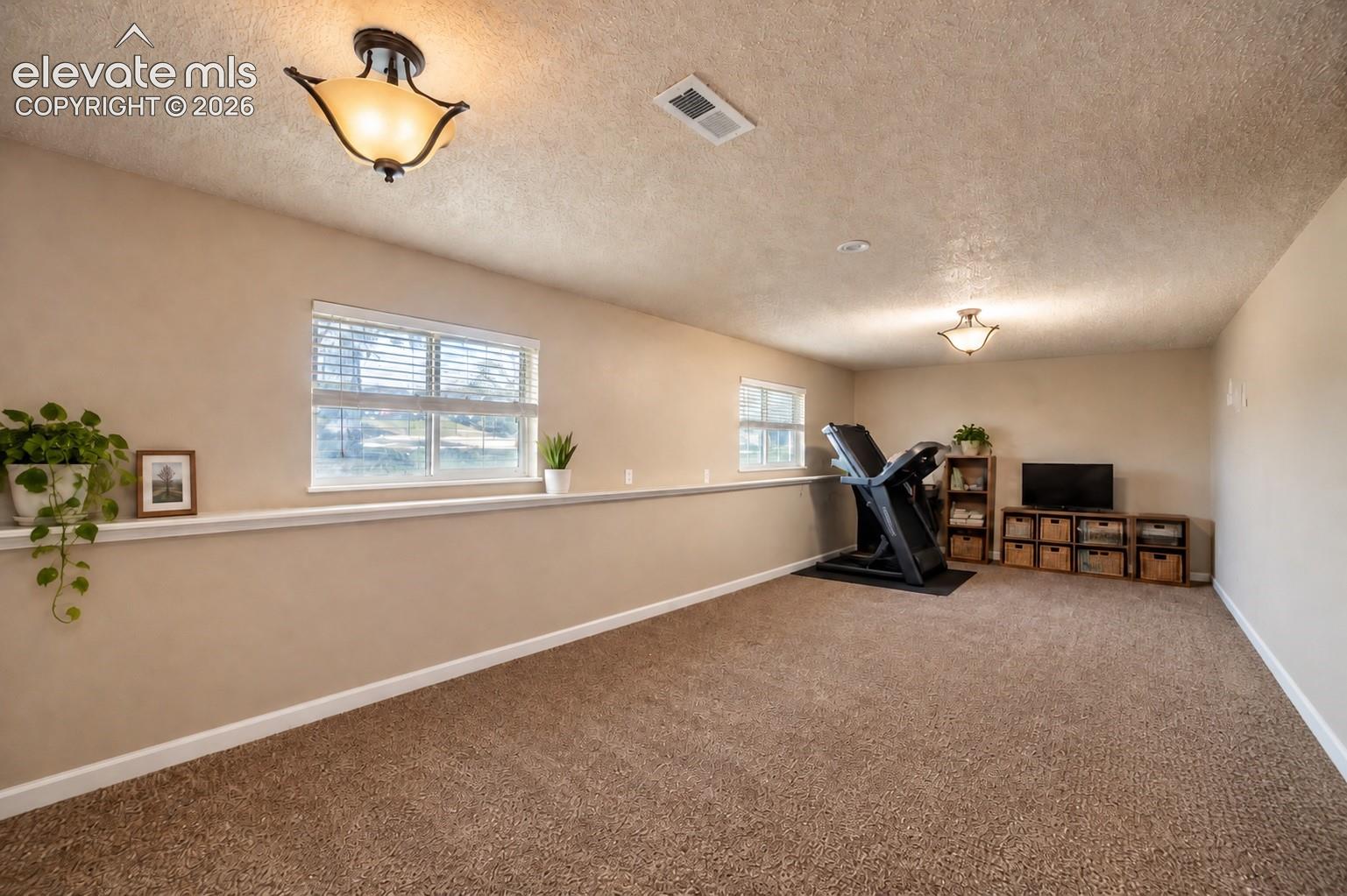 Carpeted flooring, recessed lighting, and multiple windows