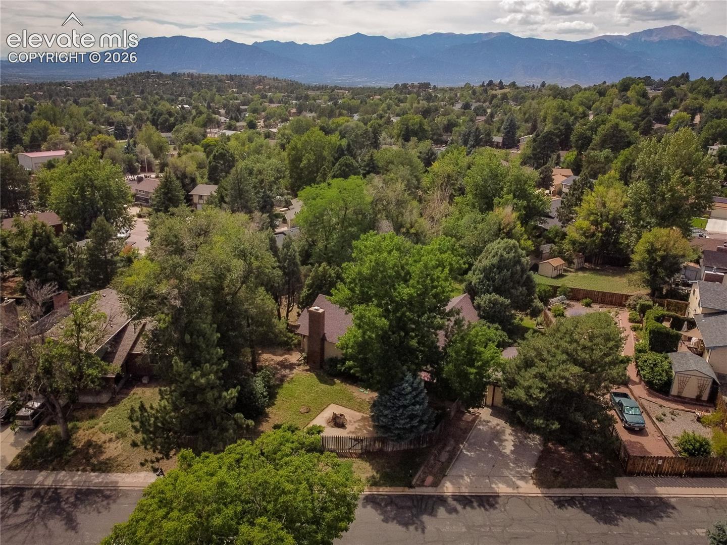 Expansive lot featuring mature trees, a private driveway, and a fenced backyard