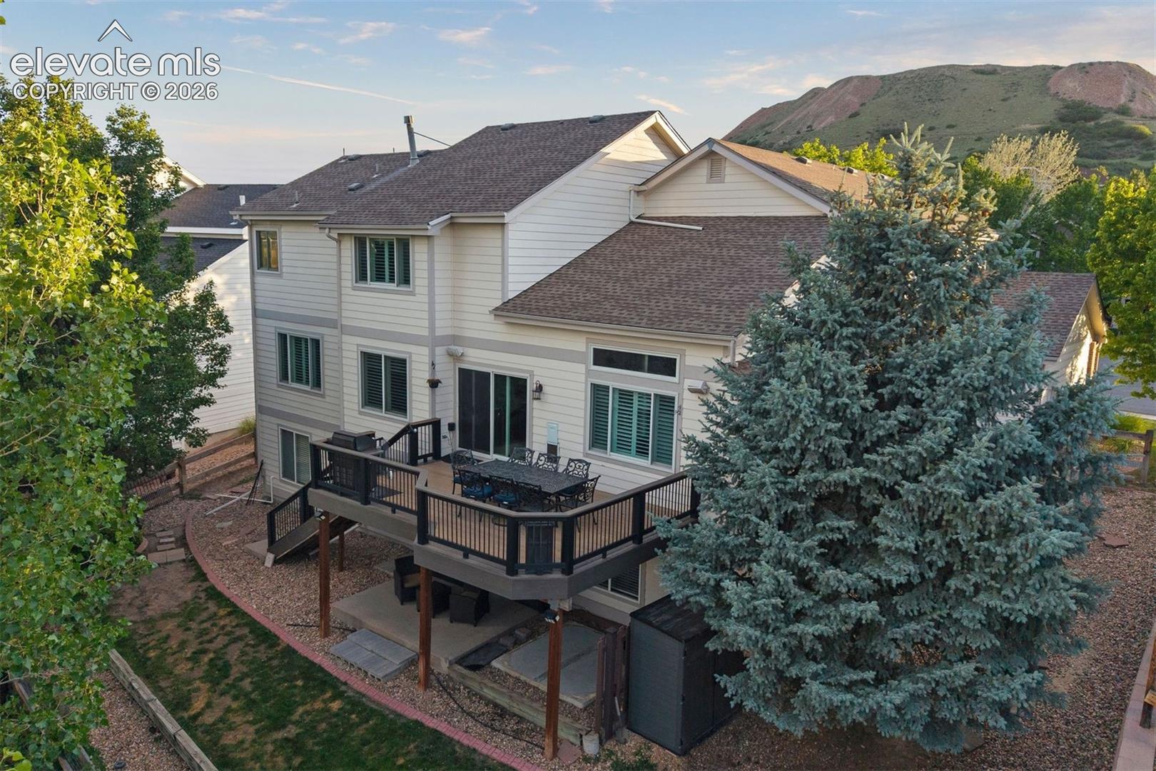 Rear exterior featuring a composite deck with black railings, a walk-out concrete patio, and a hot-tub pad.