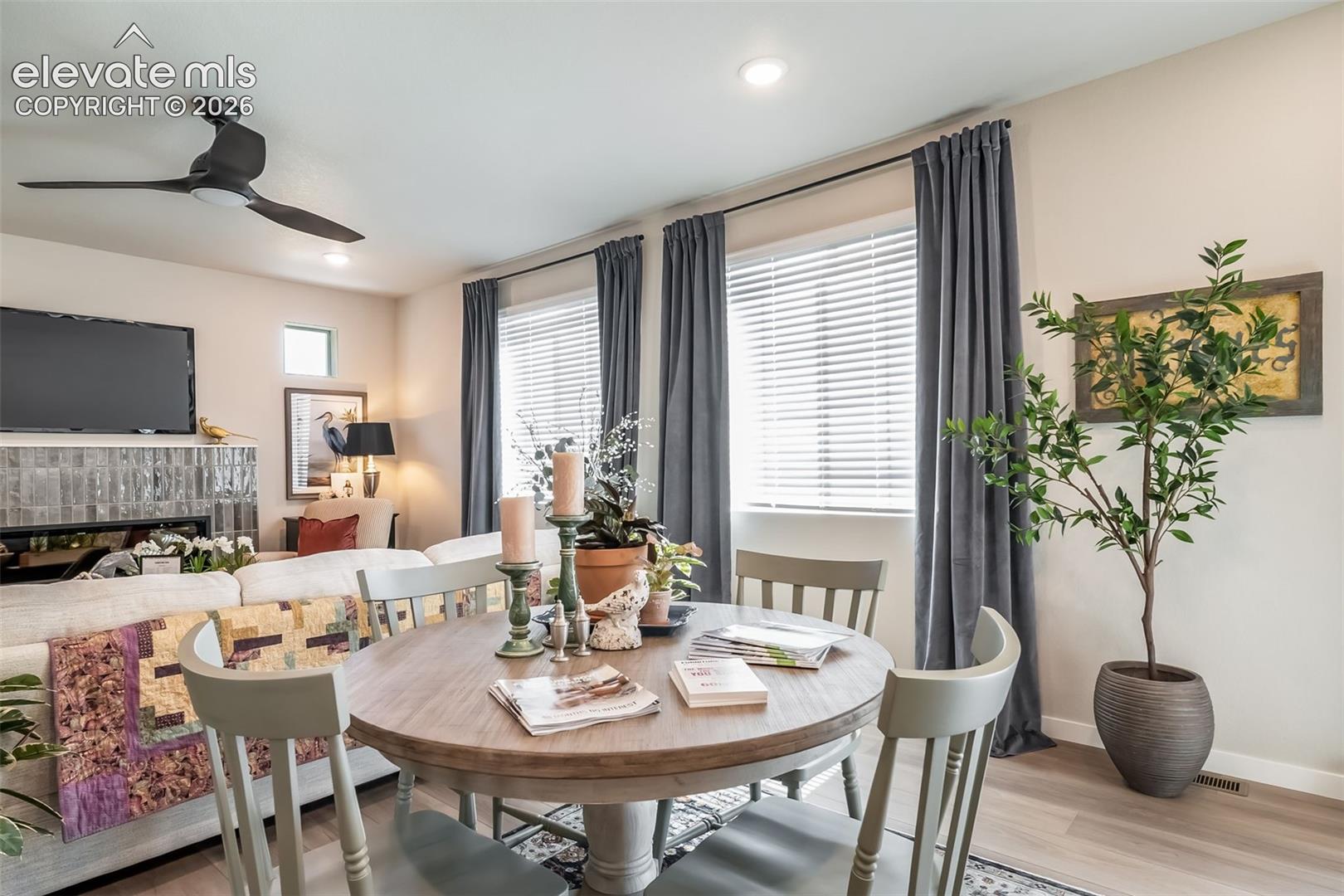 Open-concept living area featuring a central dining space with wood-finish flooring
*Photos of a model home*