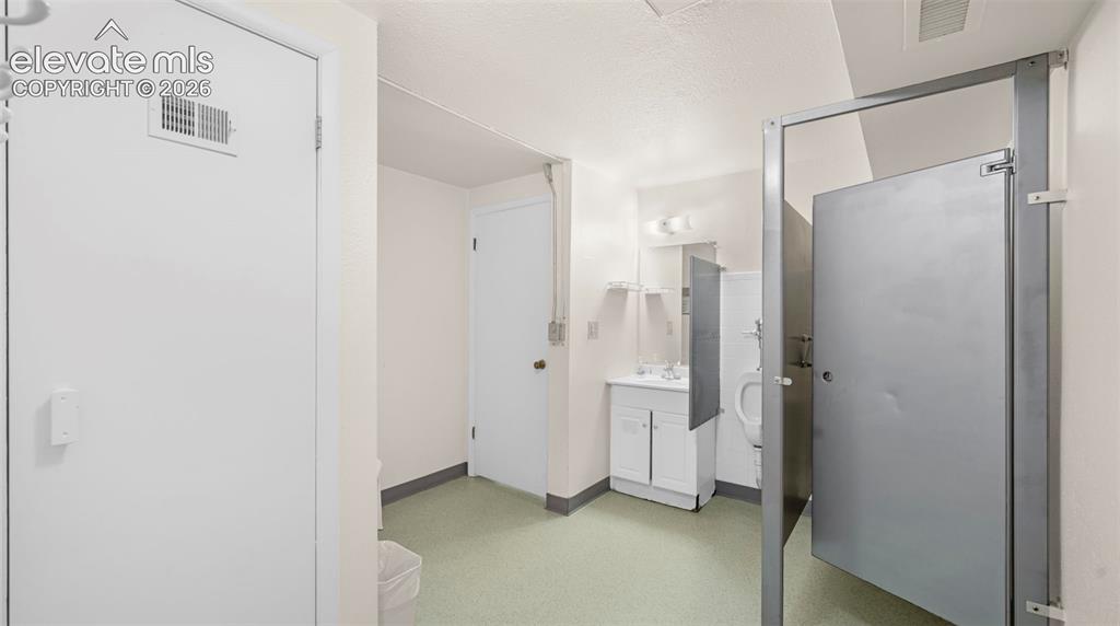 Restroom area featuring light green flooring and white walls