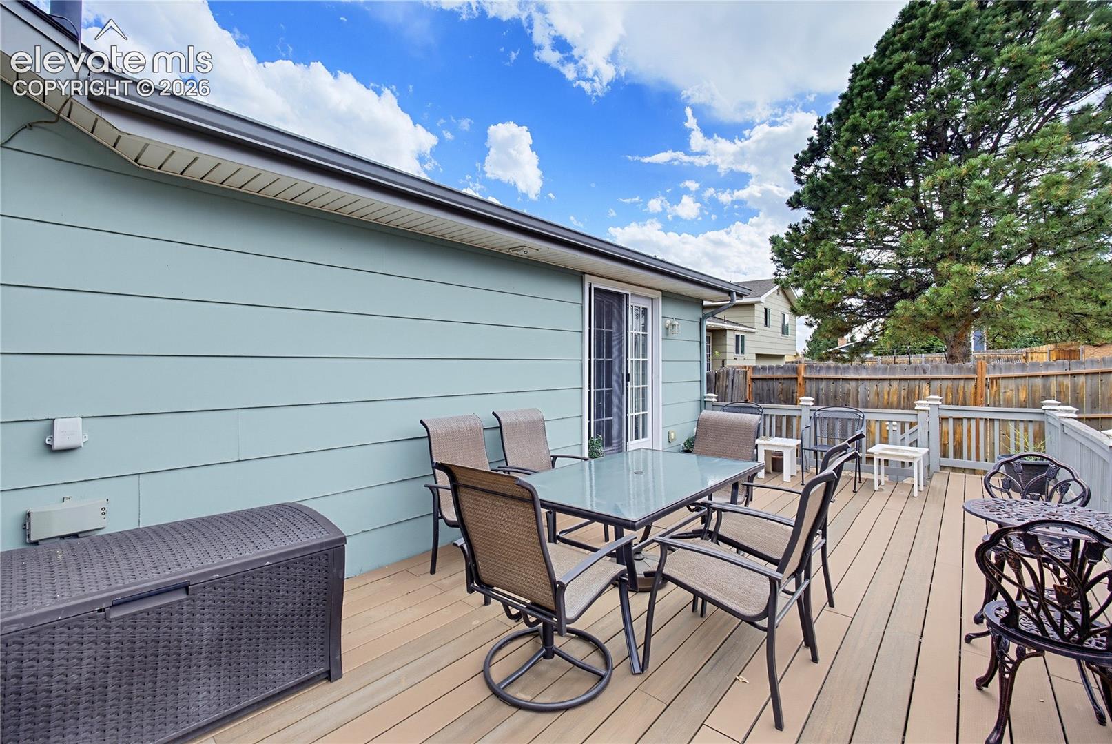 Expansive outdoor deck with composite decking, white exterior trim, and a privacy fence