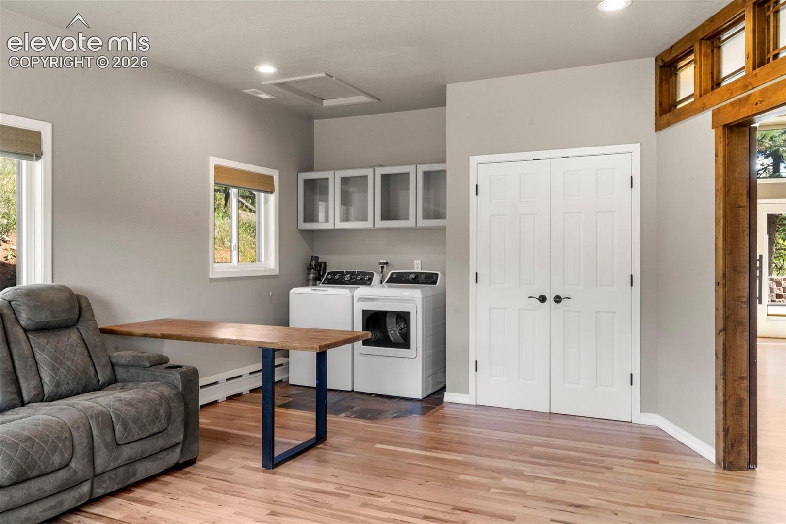 Office area with light wood-style floors, recessed lighting, a baseboard heating unit, and washer and dryer