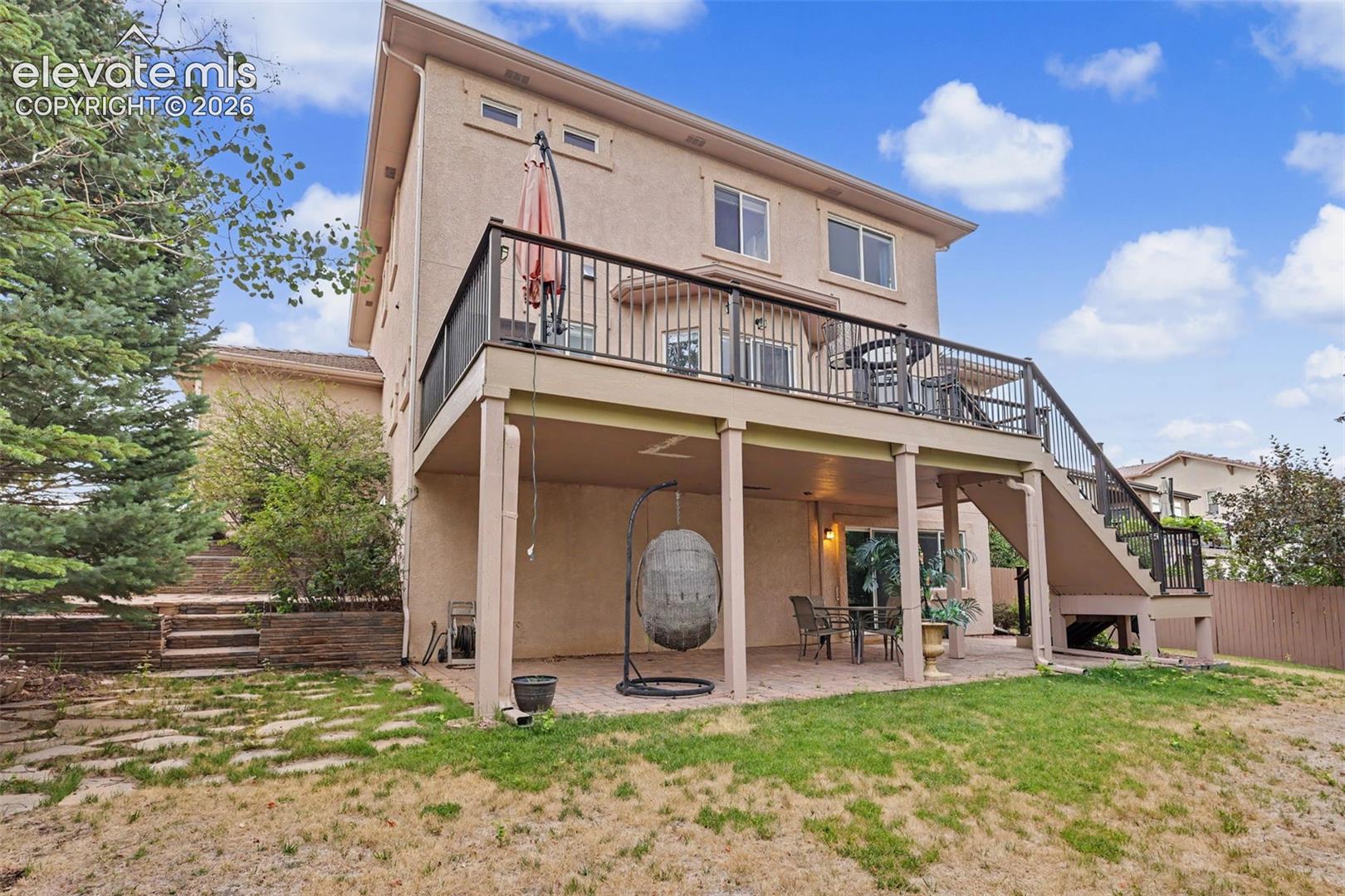 Rear exterior featuring a two-story design with a stucco finish