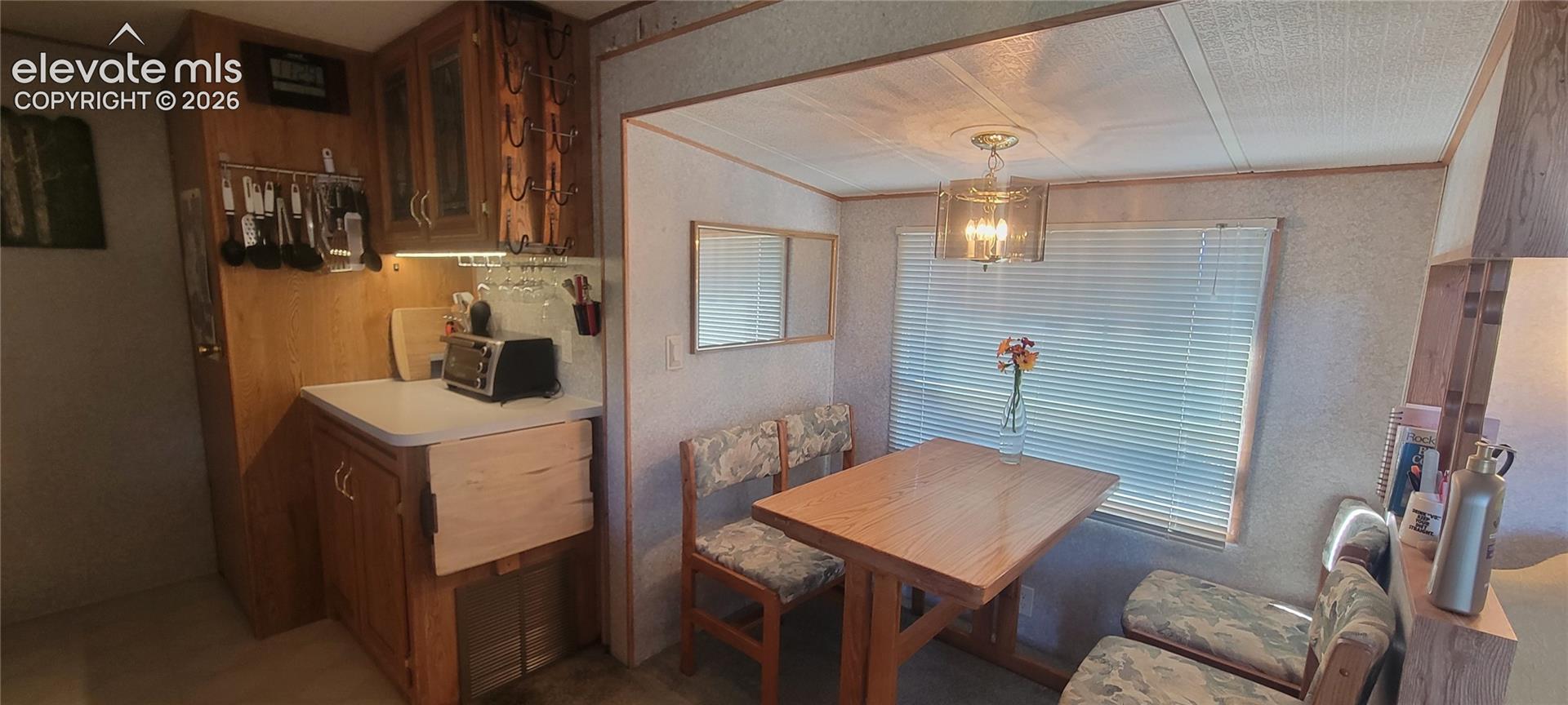 Wood-finish cabinetry with glass-front upper cabinets, built-in wine storage, and under-cabinet lighting