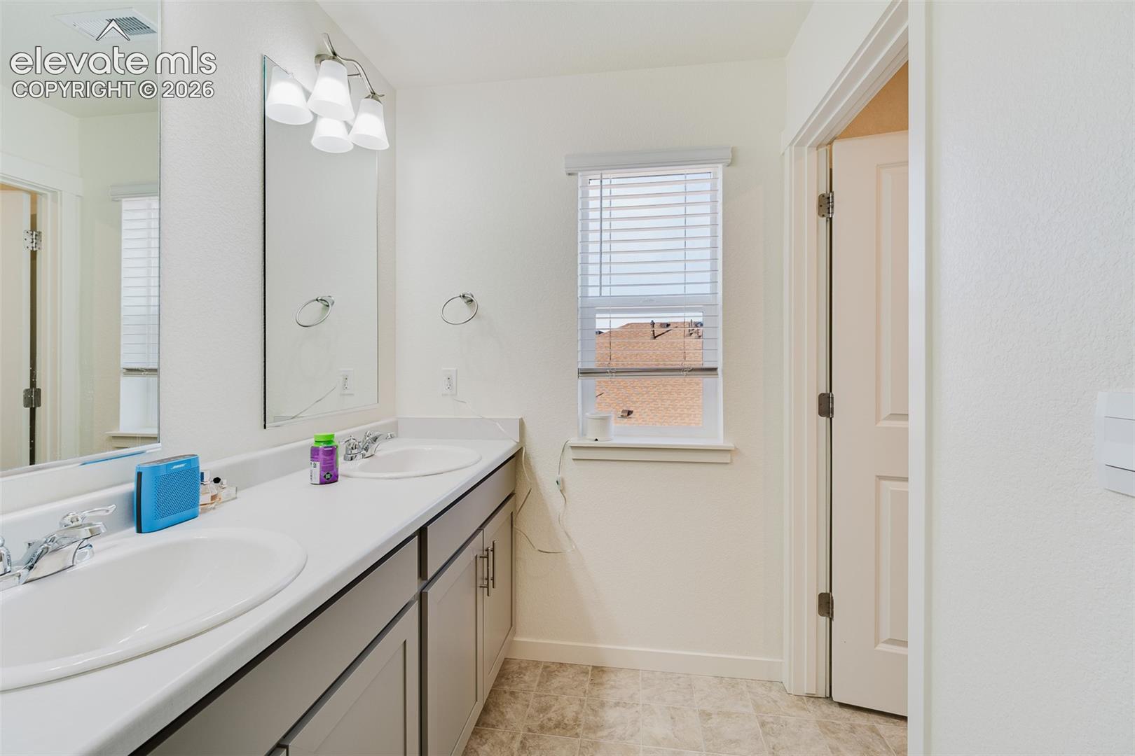 Upper Level Full Bathroom with dual sink vanity, mirrors, and tub/shower.