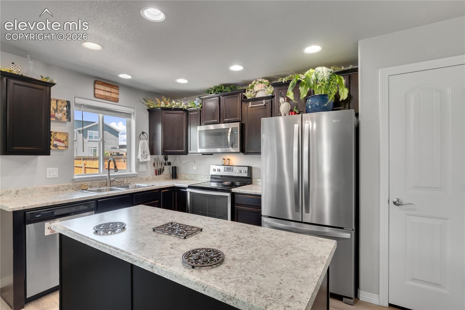 Kitchen featuring an L-shaped counter, a center island, recessed lighting, and stainless steel appliances