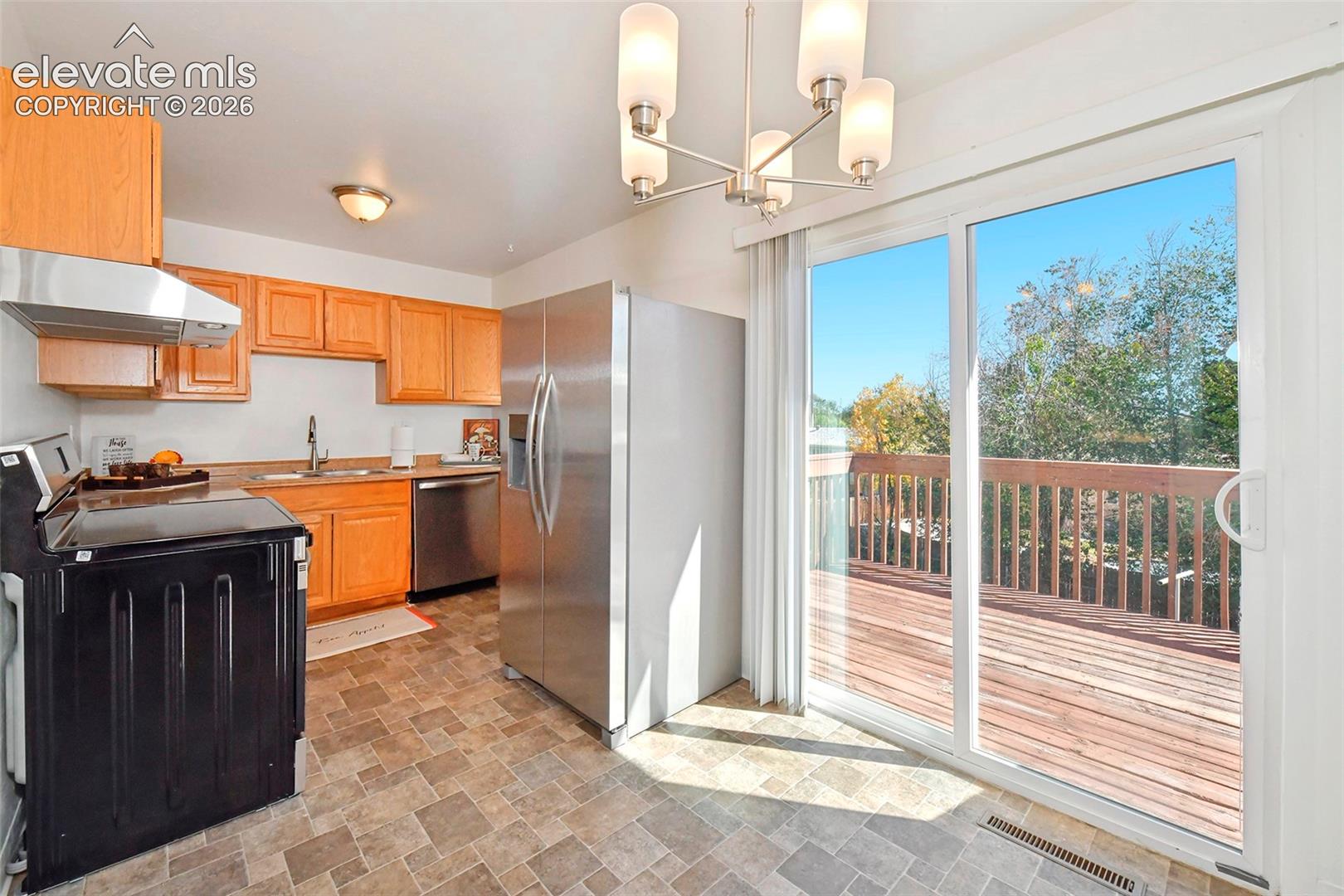 Kitchen new stainless steel appliances, and a sliding glass door providing access to a wood deck