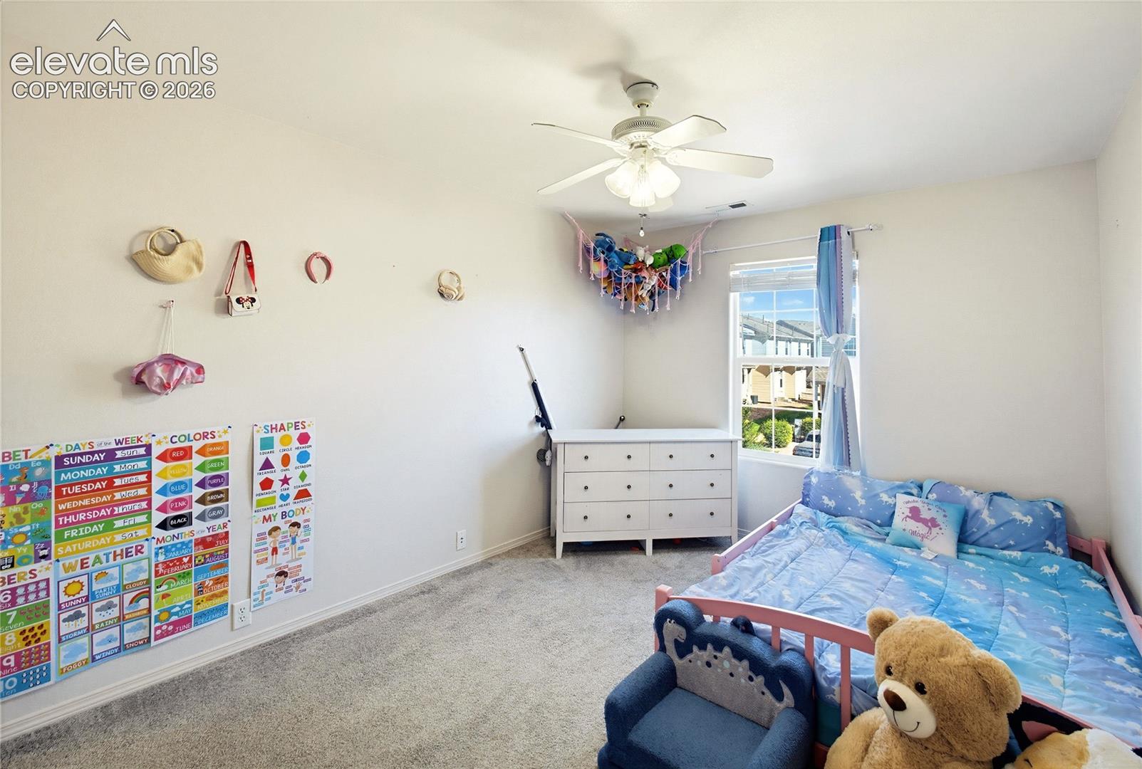 Recessed window, ceiling fan, white dresser, carpeted flooring, and white walls
