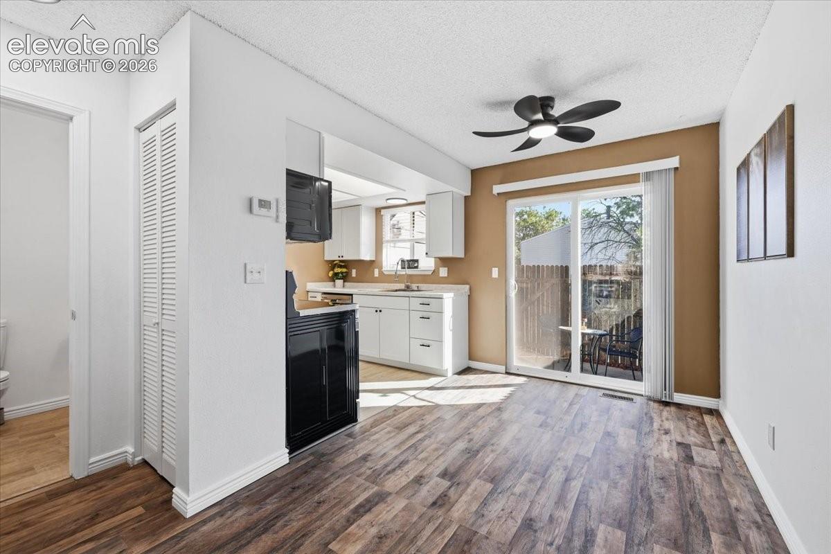 Wood-finish flooring, white walls, and a sliding glass door to the patio