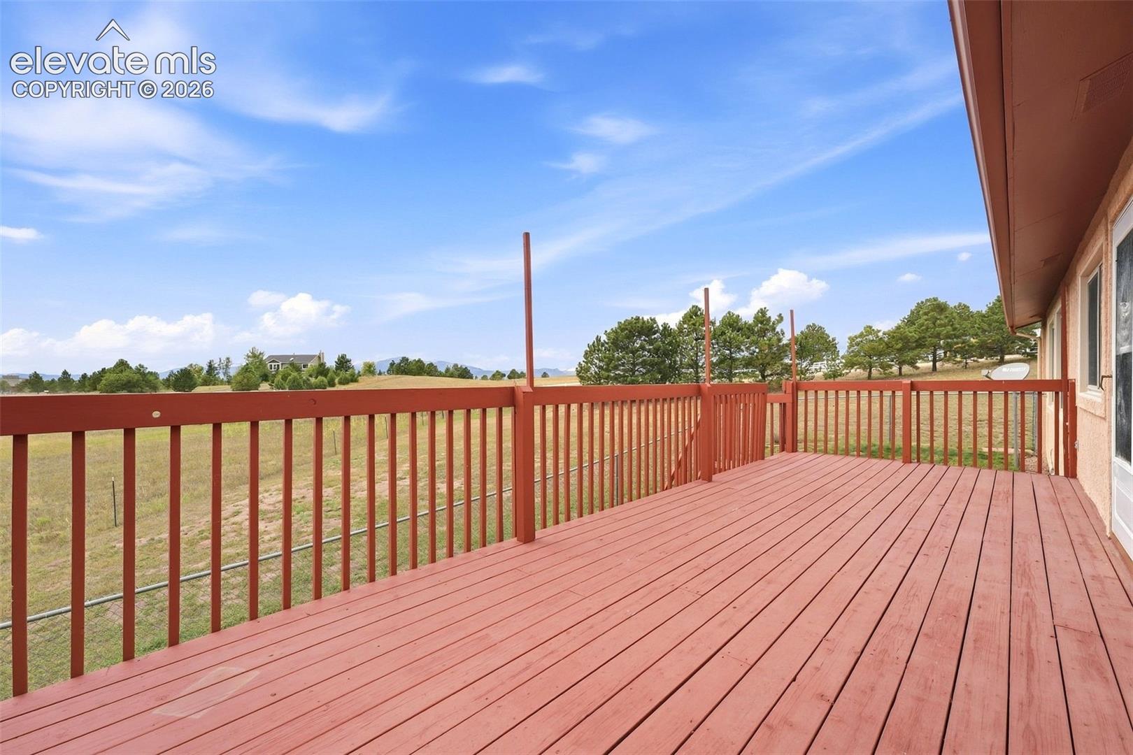 Expansive outdoor deck with wood-finish flooring and railing