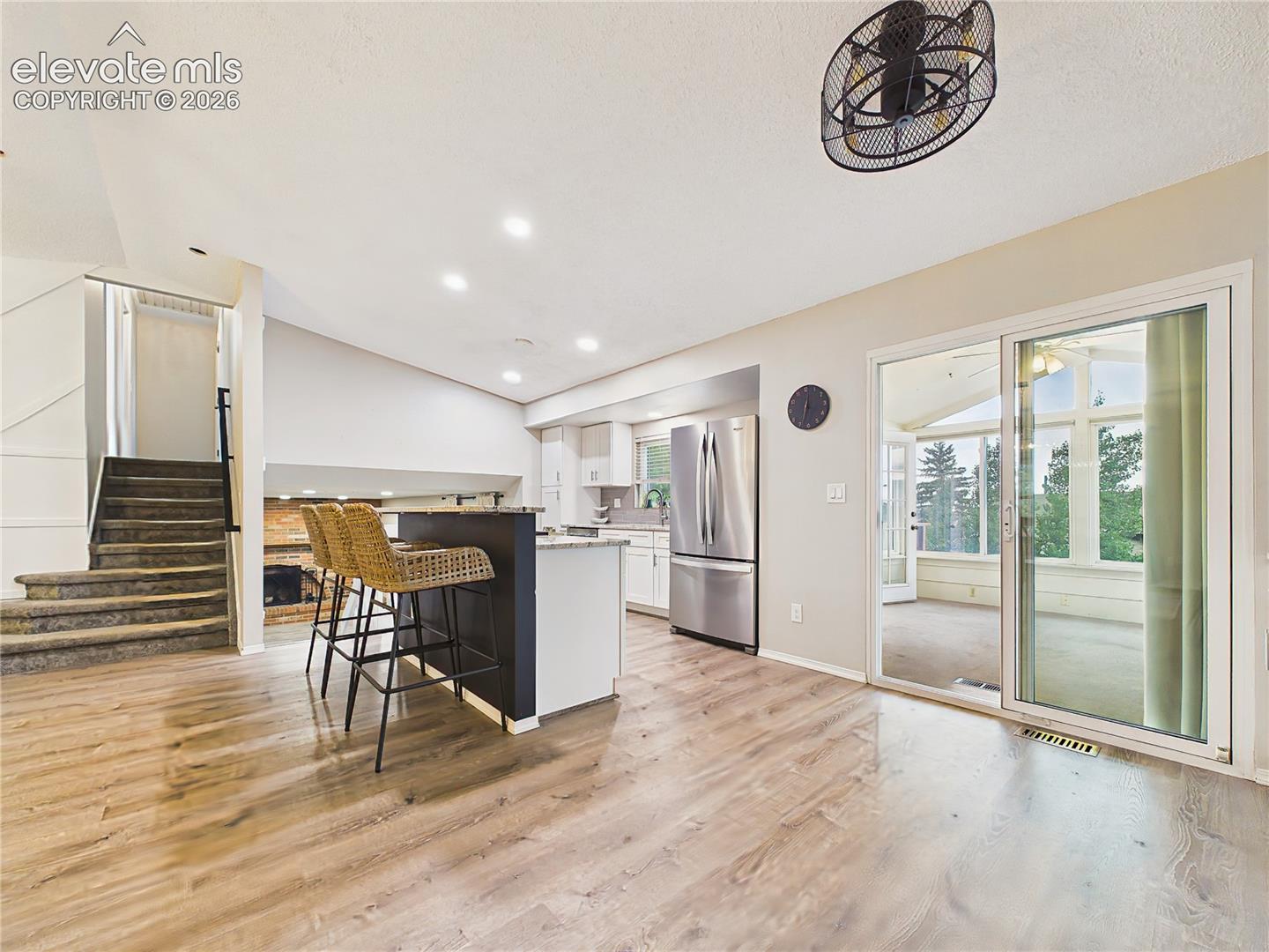 Kitchen & Sunroom Access – Open kitchen layout with breakfast bar seating and sliding glass doors leading directly to the enclosed sunroom, creating an ideal flow for everyday living.