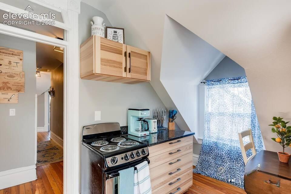 Kitchen shows much of the old victorian character with dormer windows and slanted ceilings.
