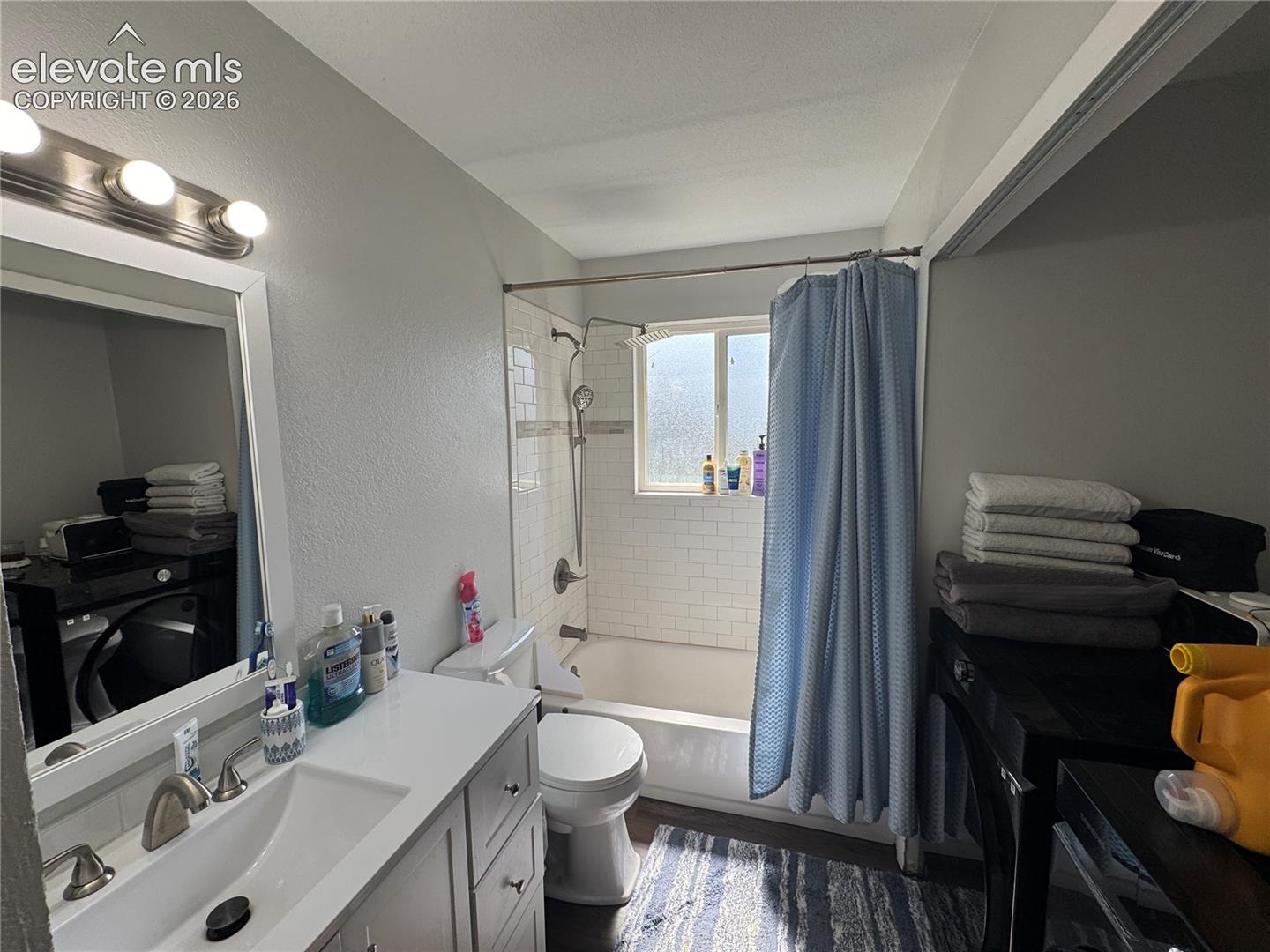 White vanity with a rectangular basin sink, brushed nickel faucet, and integrated counter space