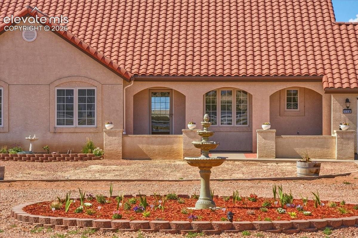 Large windows and patio access create a seamless connection between indoor living spaces and the front yard