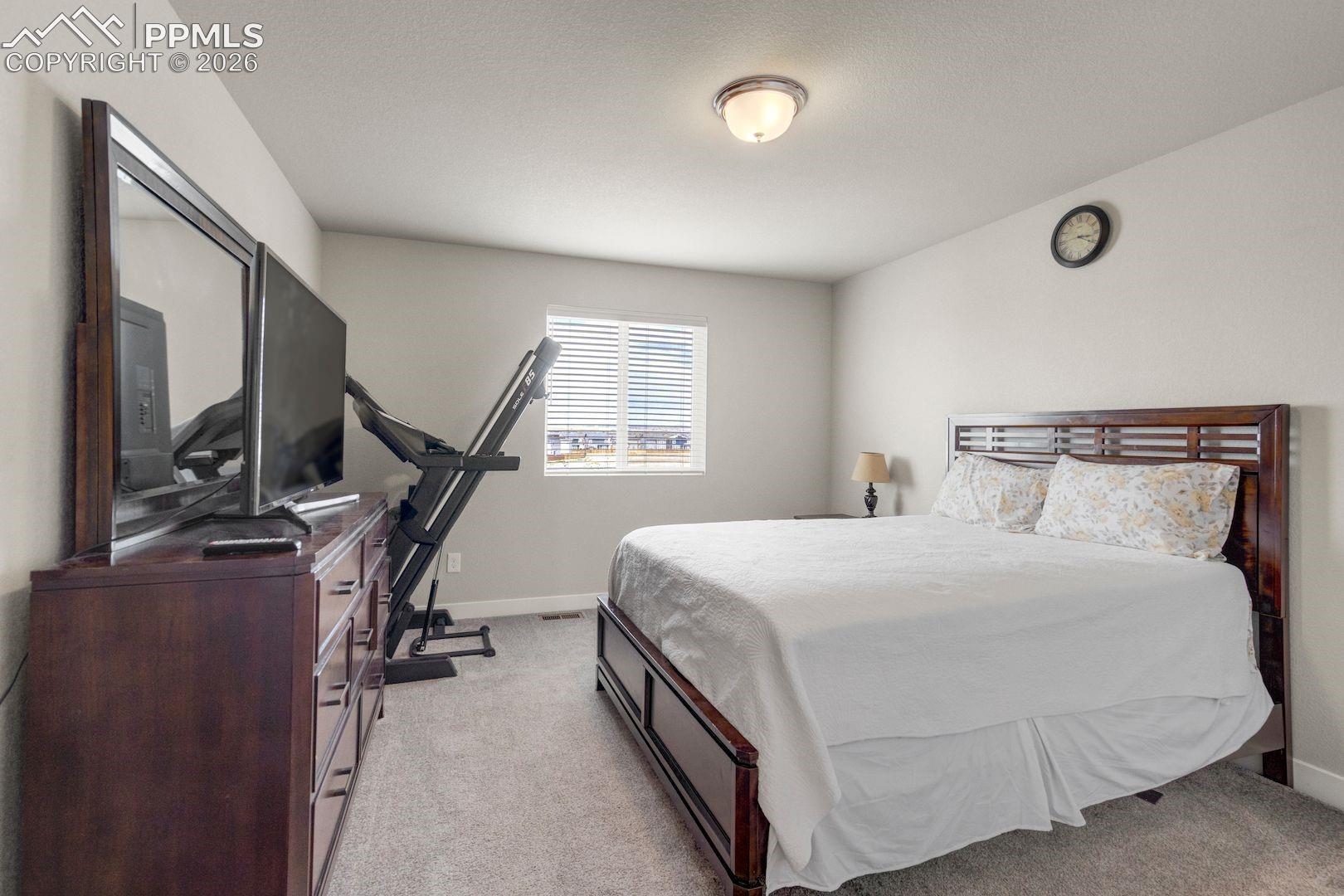 Bedroom featuring light colored carpet and baseboards