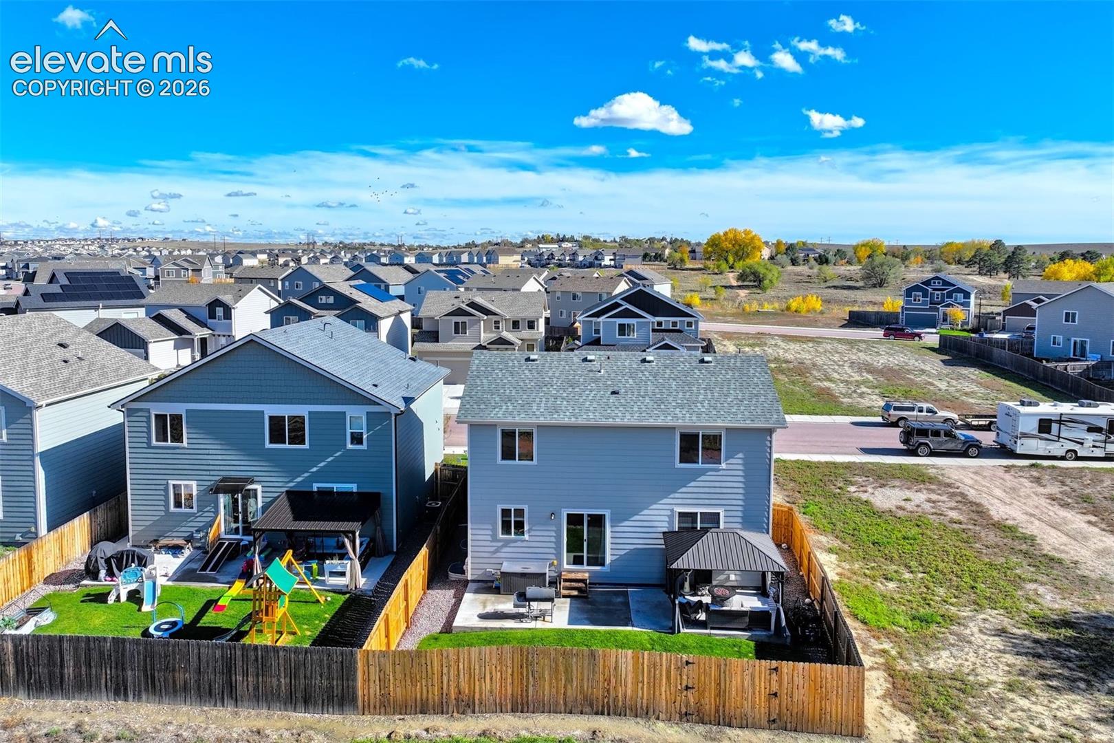 Two-story detached residences featuring lap siding, asphalt shingle roofing, rear concrete patios, and wood privacy fencing