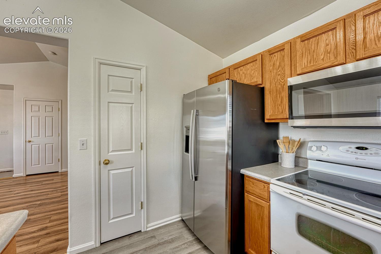 Stainless steel refrigerator, smooth top range/oven, and built-in microwave.
