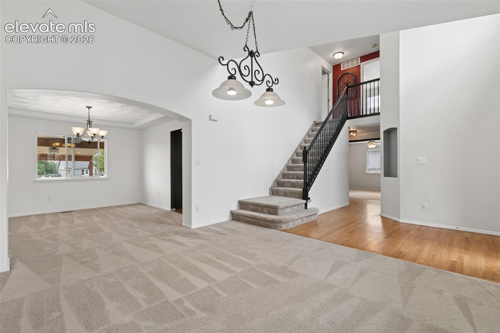 Open Layout with Wood Flooring & Dramatic Staircase