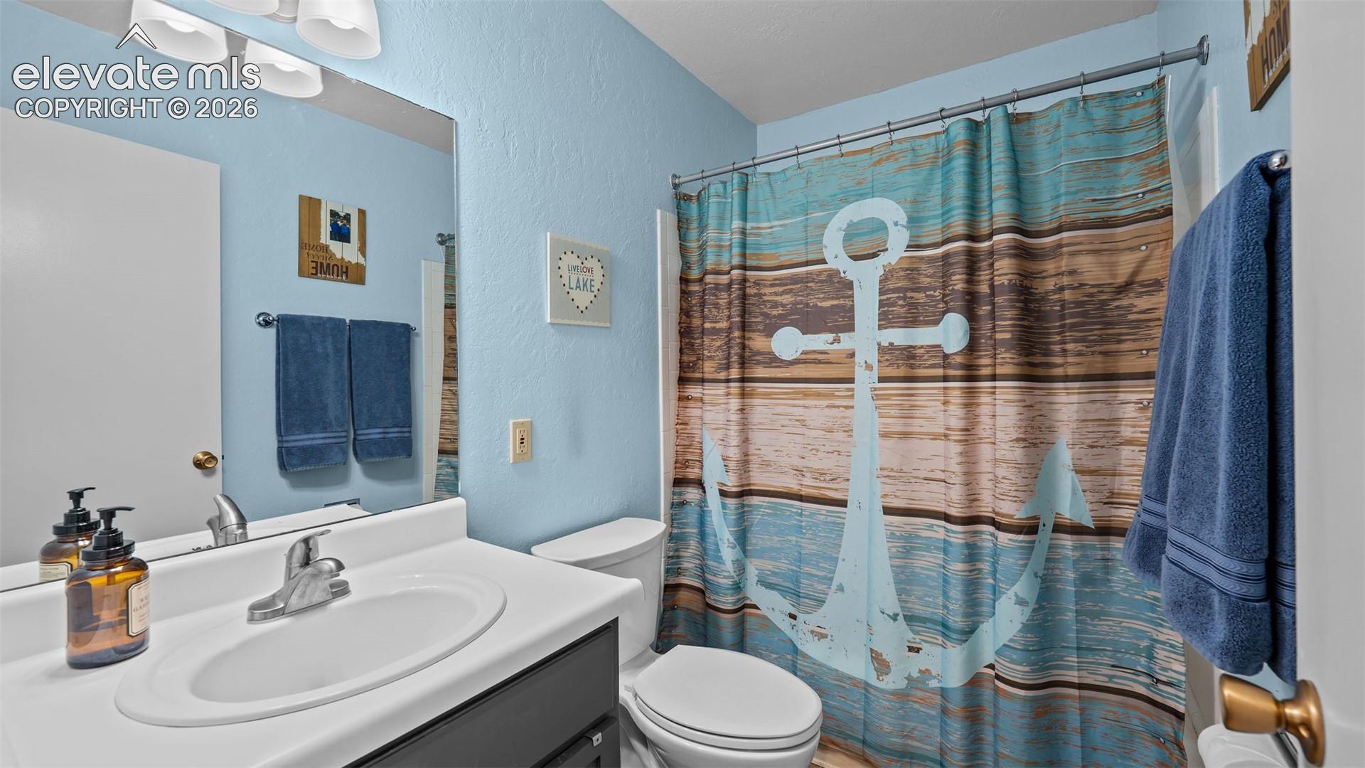 Bathroom featuring a vanity with an integrated basin, chrome faucet, wall-mounted mirror, three-light fixture, and a combination shower and tub