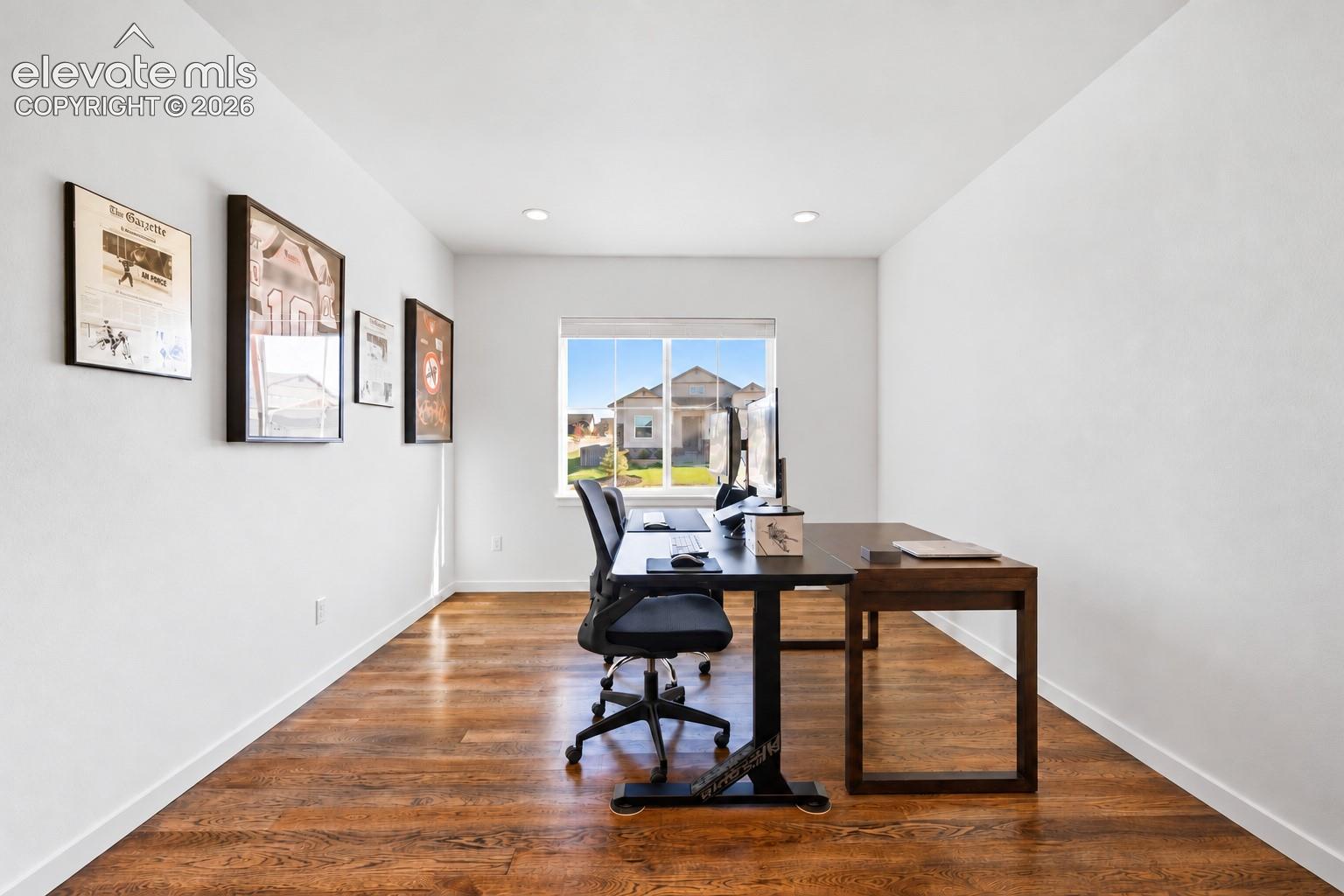 This second main-floor bedroom is currently in use as an office. It has French doors, hardwood floors and a double window with a front-facing view. 
