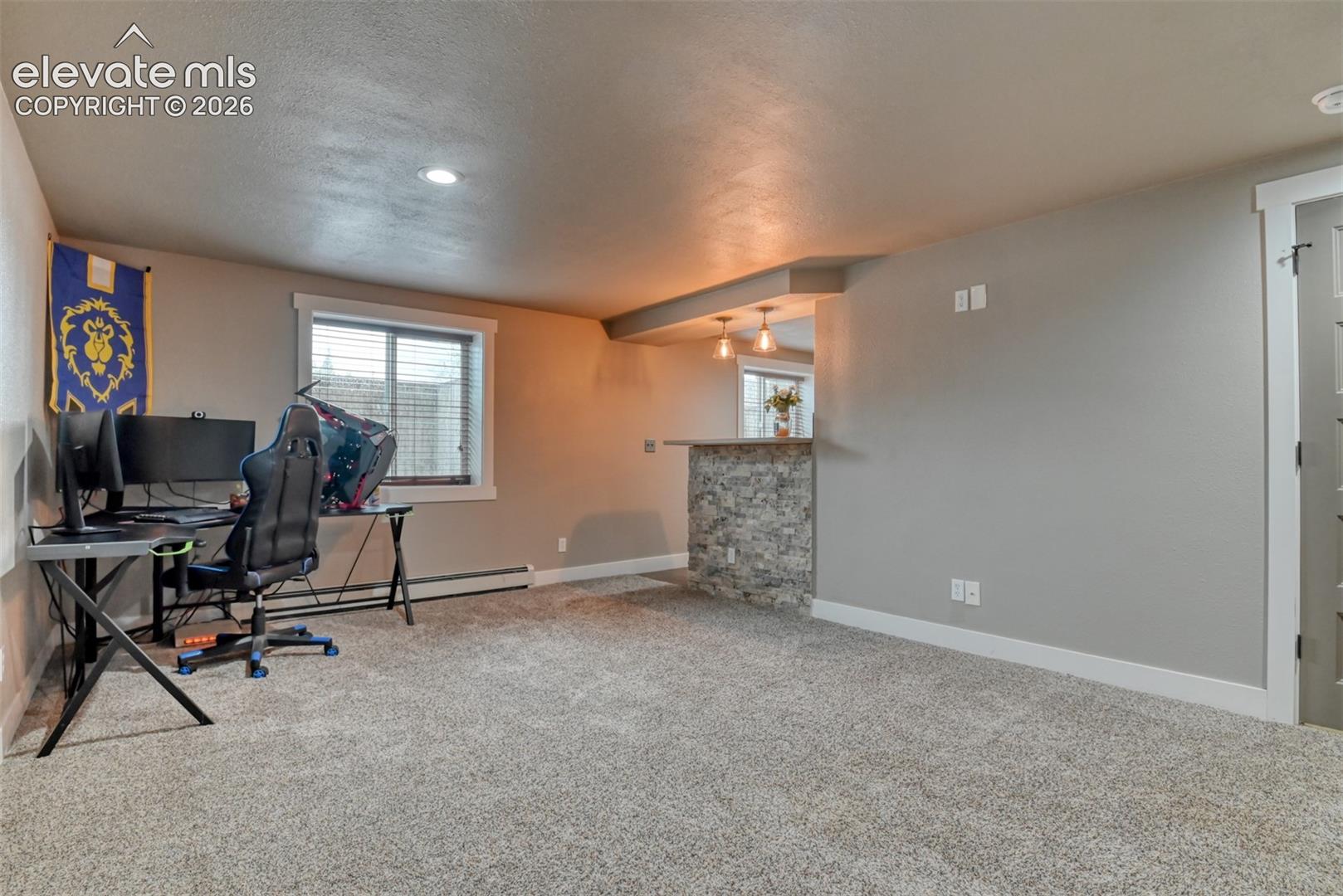 Office space with light carpet and baseboard heating