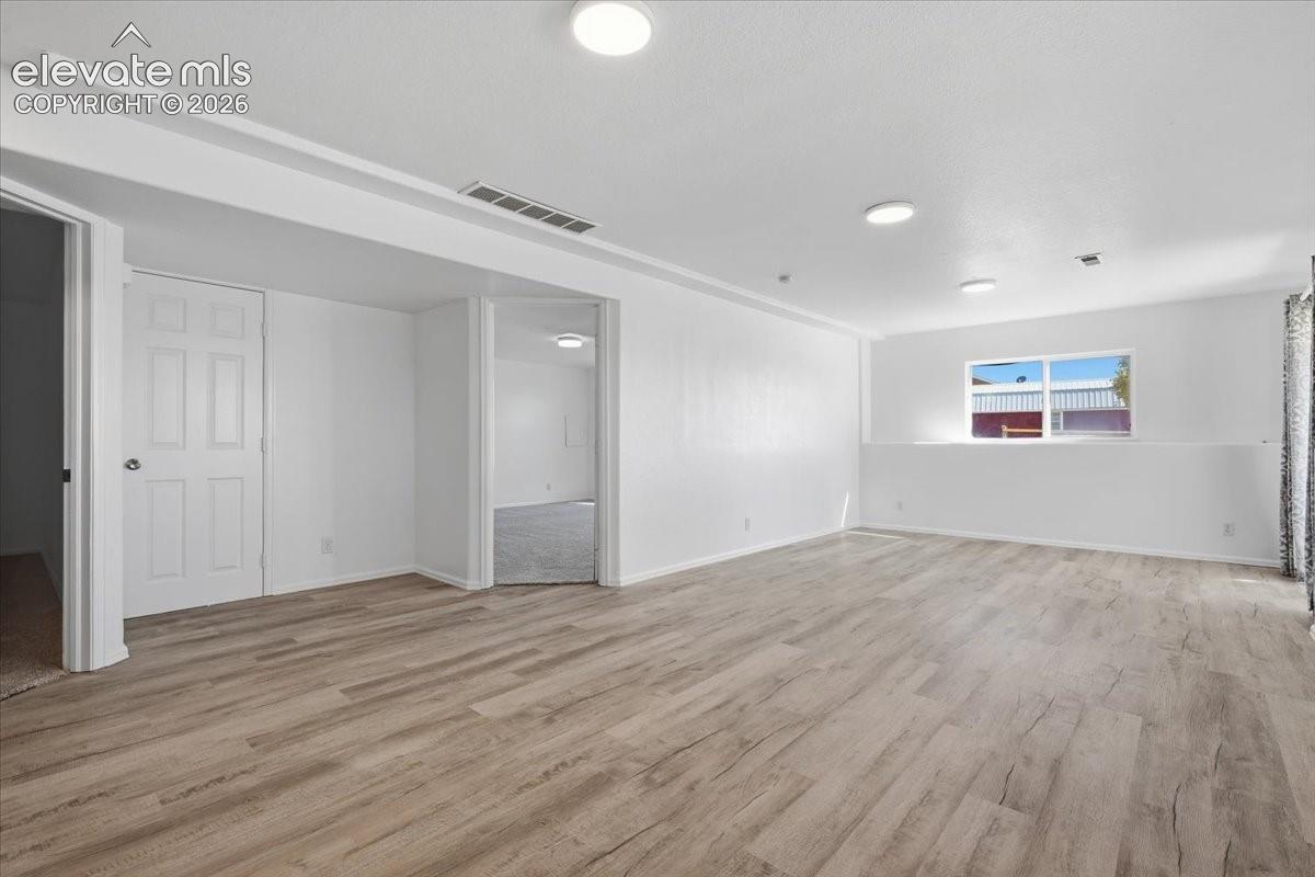 Open-concept interior featuring wood-finish flooring, recessed lighting, and a neutral color palette