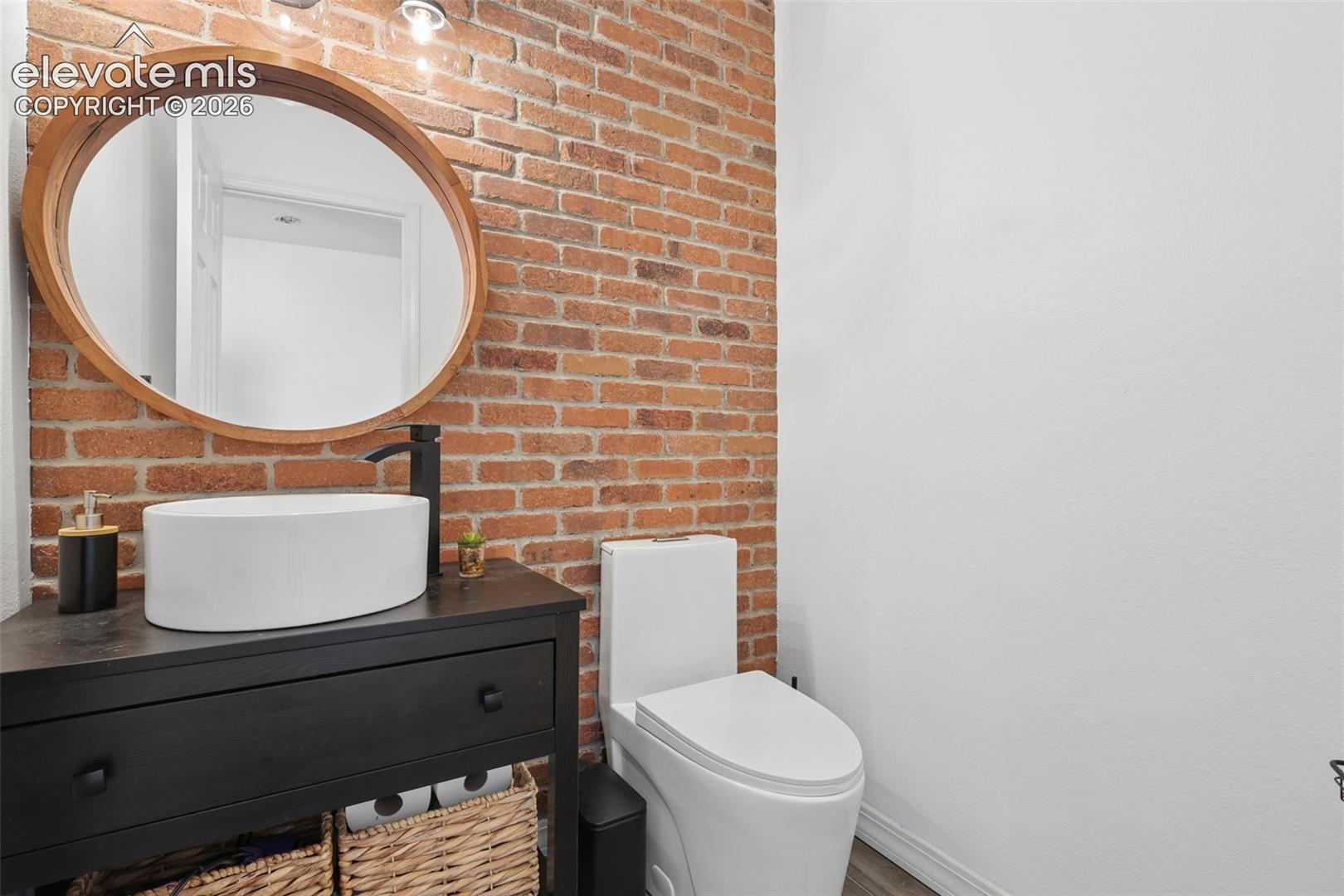 Half-powder bath on  main with brick wall accent