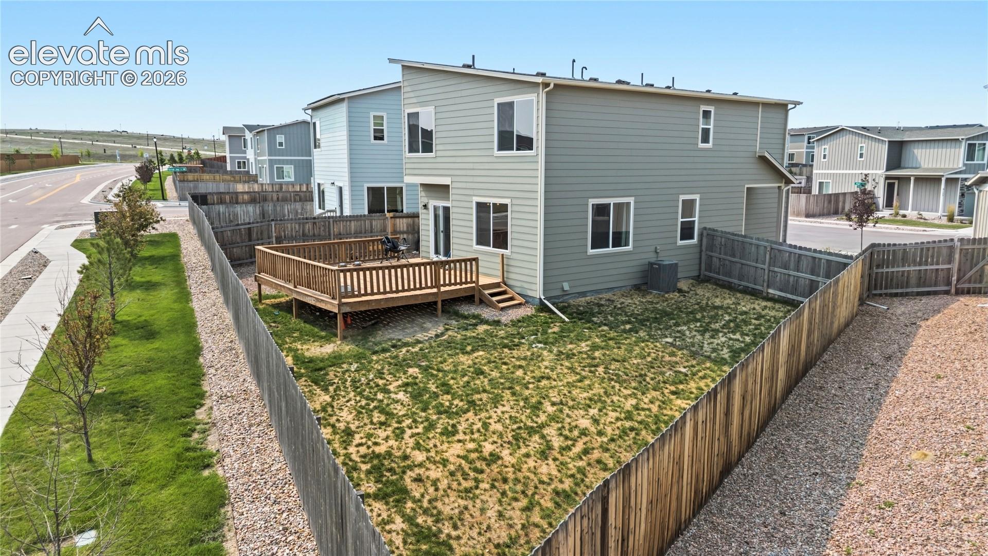 Rear view of home and fenced backyard.