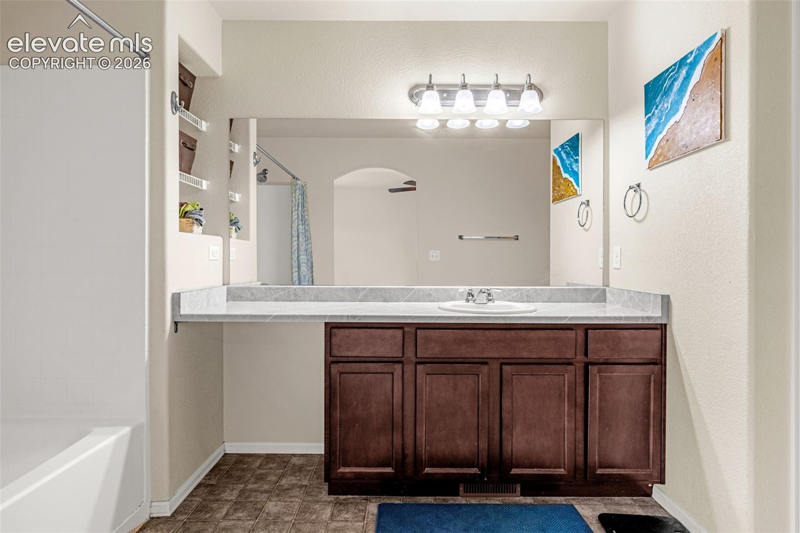 Dark wood-finish vanity with a light-toned countertop and integrated sink