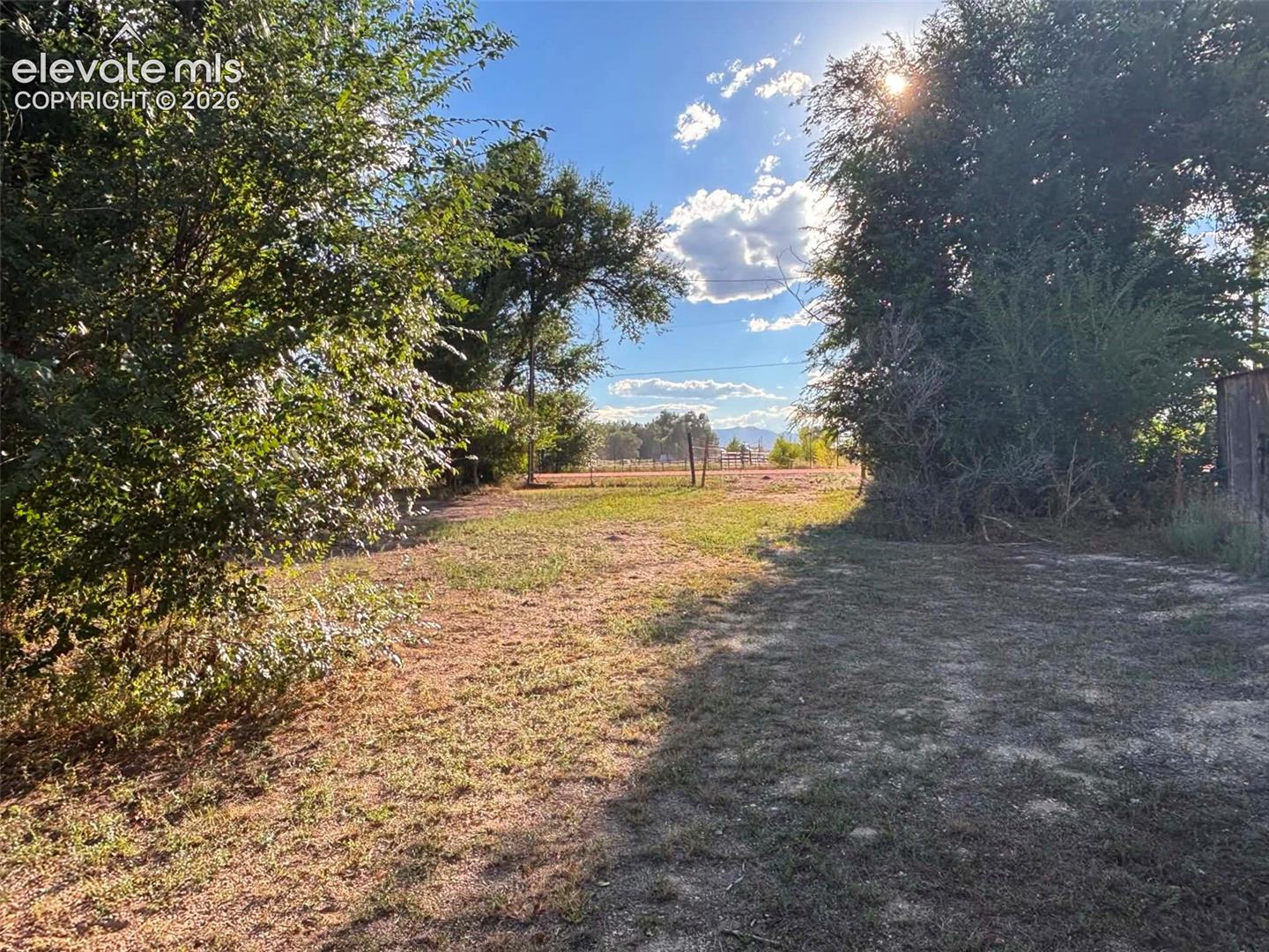 Expansive lot featuring mature trees, natural landscape, and distant mountain topography