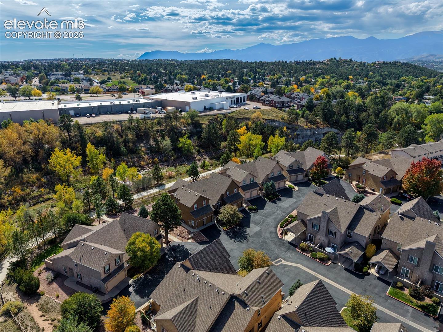 Residential development with varied rooflines, paved private drives, and mature trees