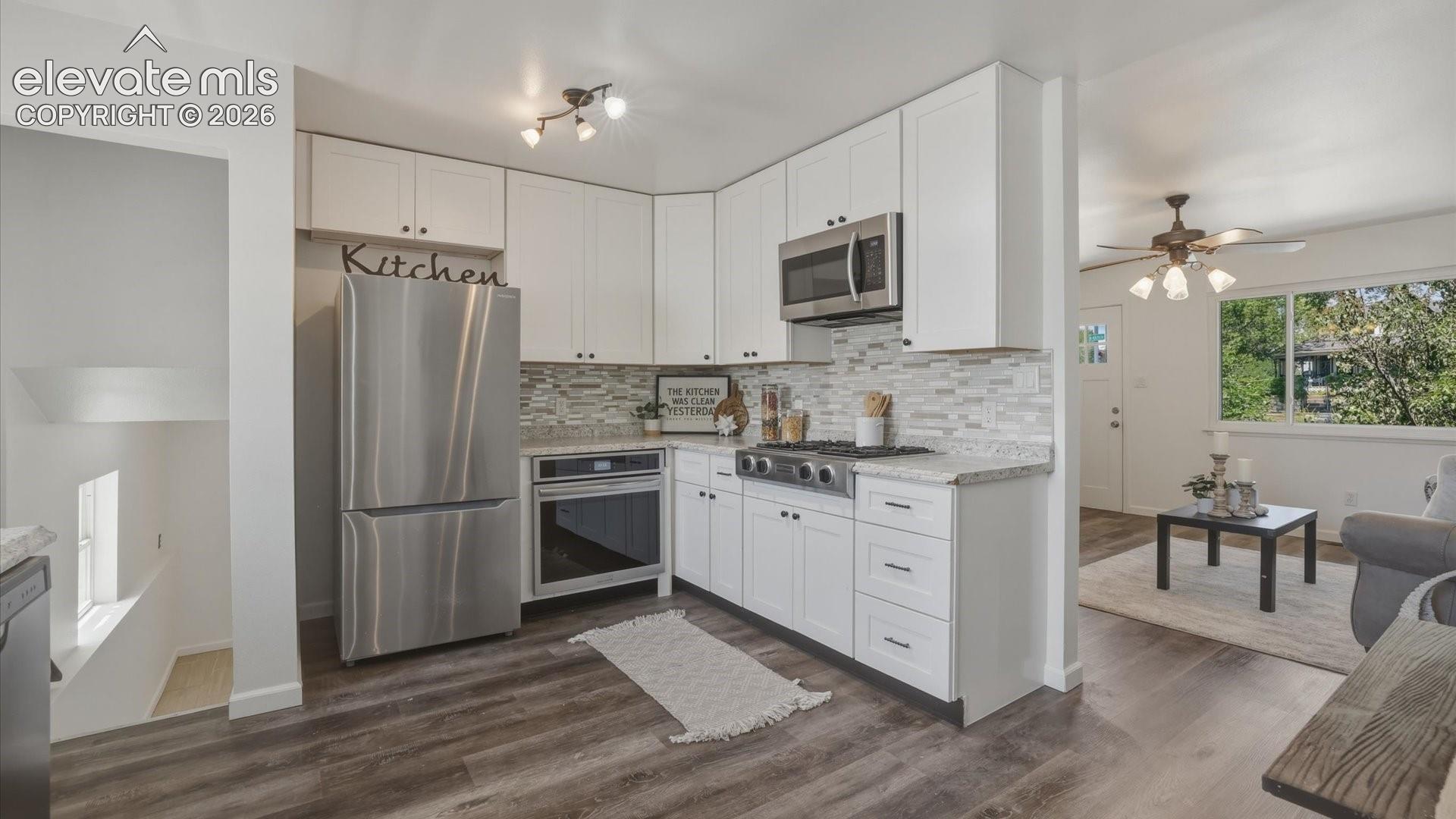 Stainless steel appliances include a gas cooktop, oven, microwave, dishwasher, and refrigerator.