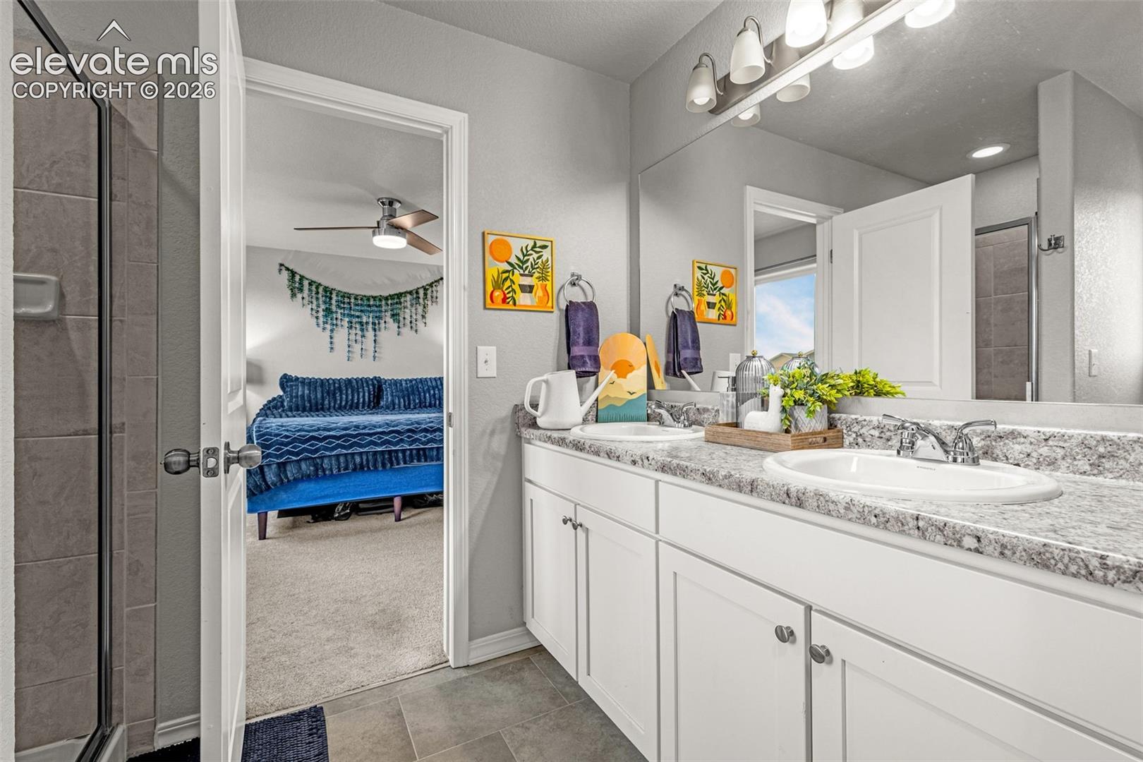 Double vanity with white cabinetry, speckled countertop, and chrome fixtures