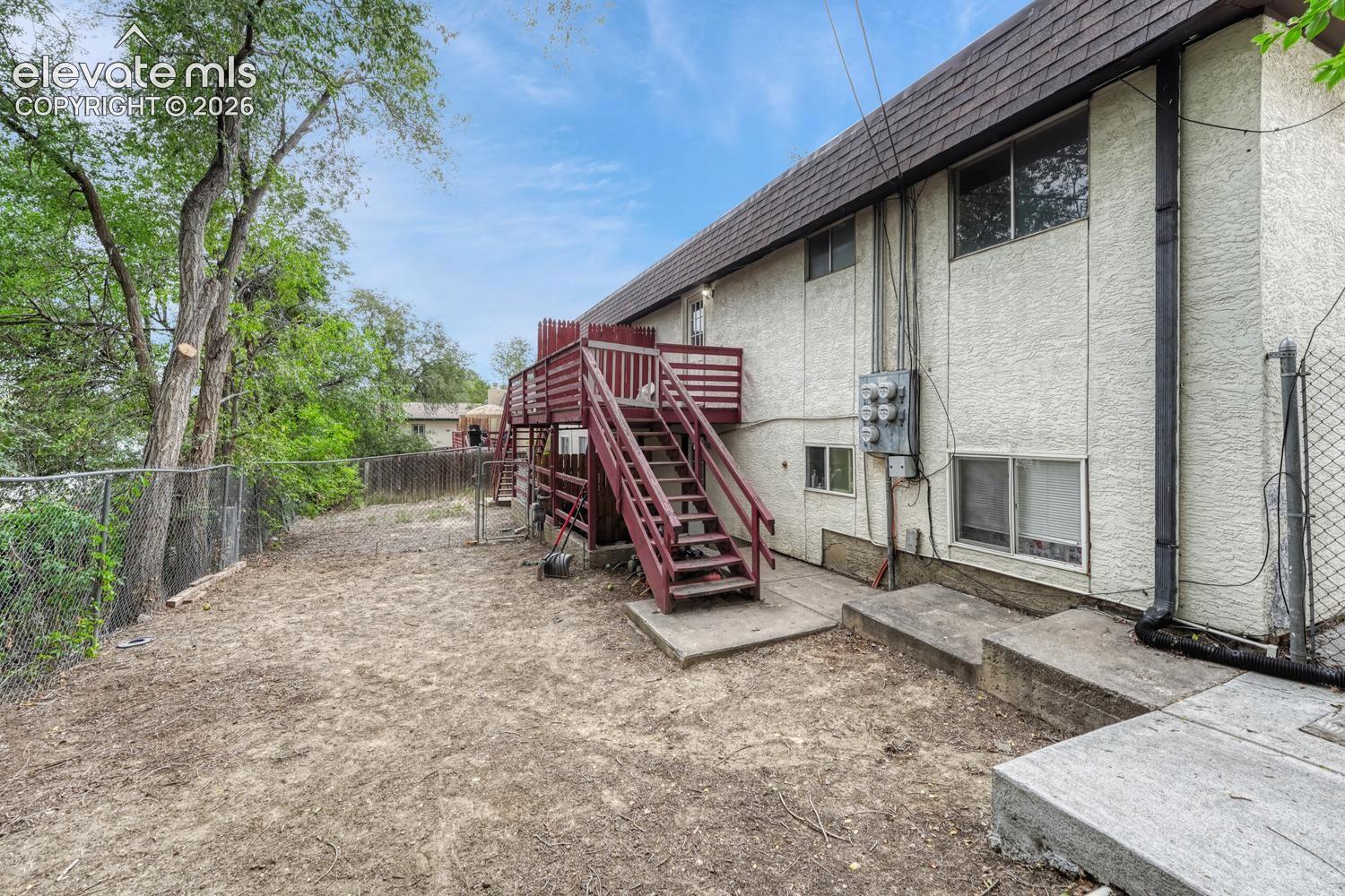 Stucco exterior with a multi-level wood deck and exterior stairs