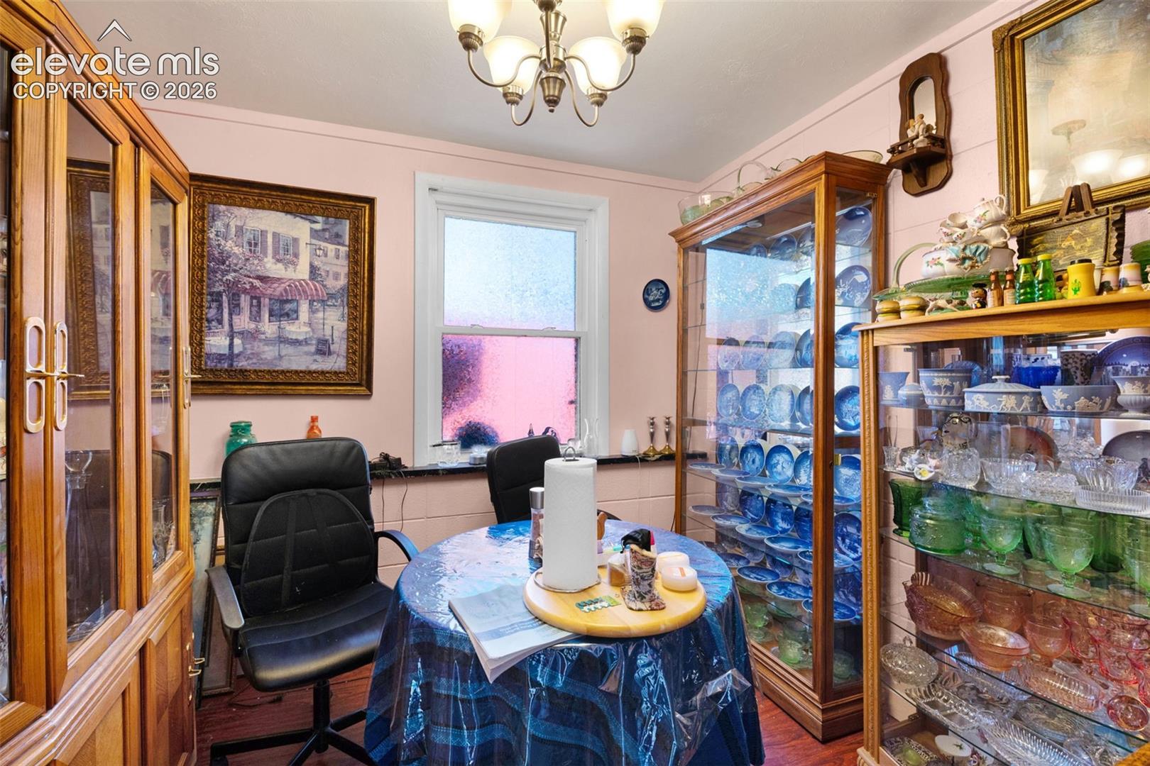 Built-in floor-to-ceiling wood cabinetry, multi-pane window, and decorative overhead chandelier