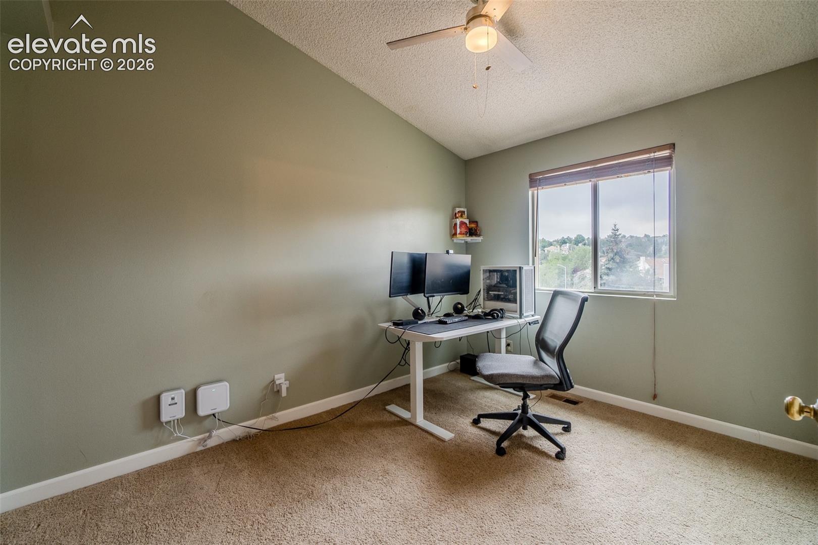 Vaulted ceiling with a ceiling fan, neutral wall paint, window with blinds, and carpeted flooring