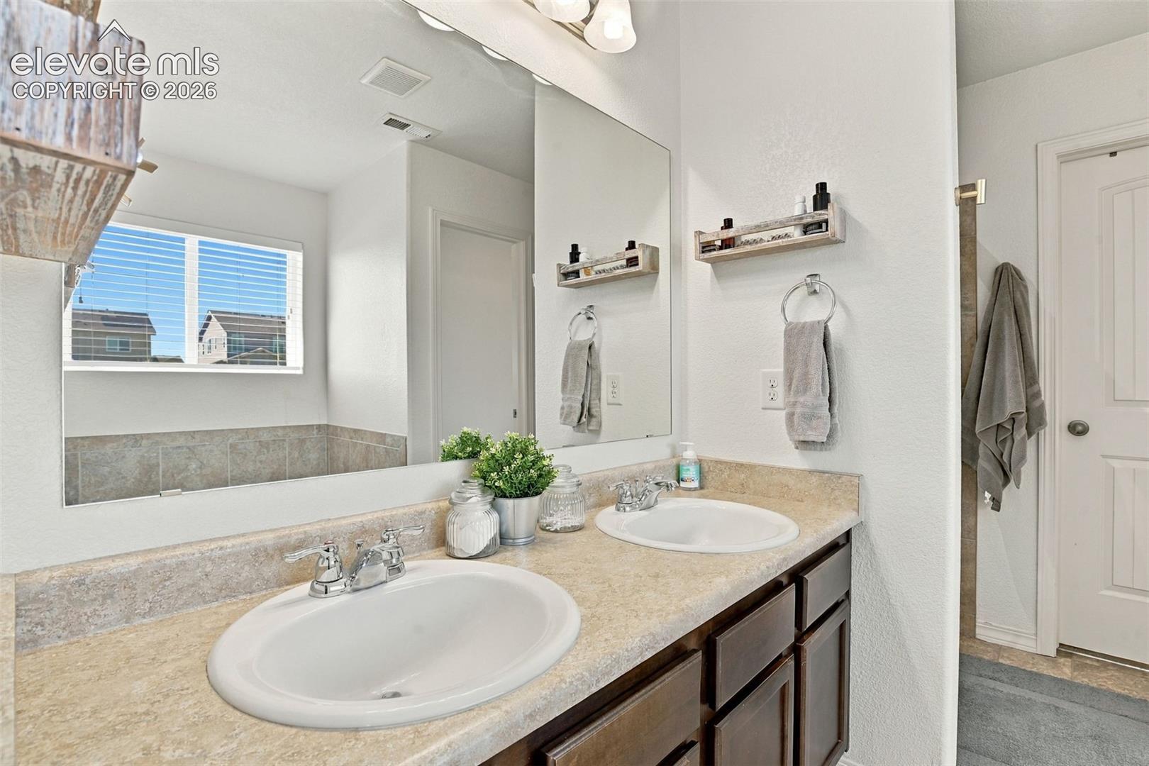 Dual vanity with integrated sinks, framed mirror, and built-in cabinetry