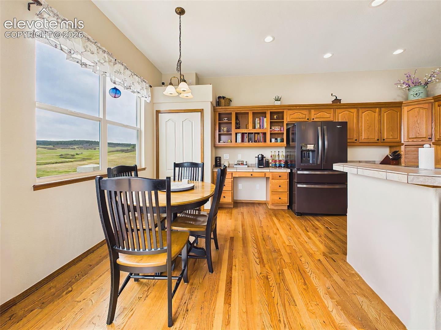 Bright breakfast area with large picture windows and peaceful views, offering the perfect setting for casual dining and morning coffee.