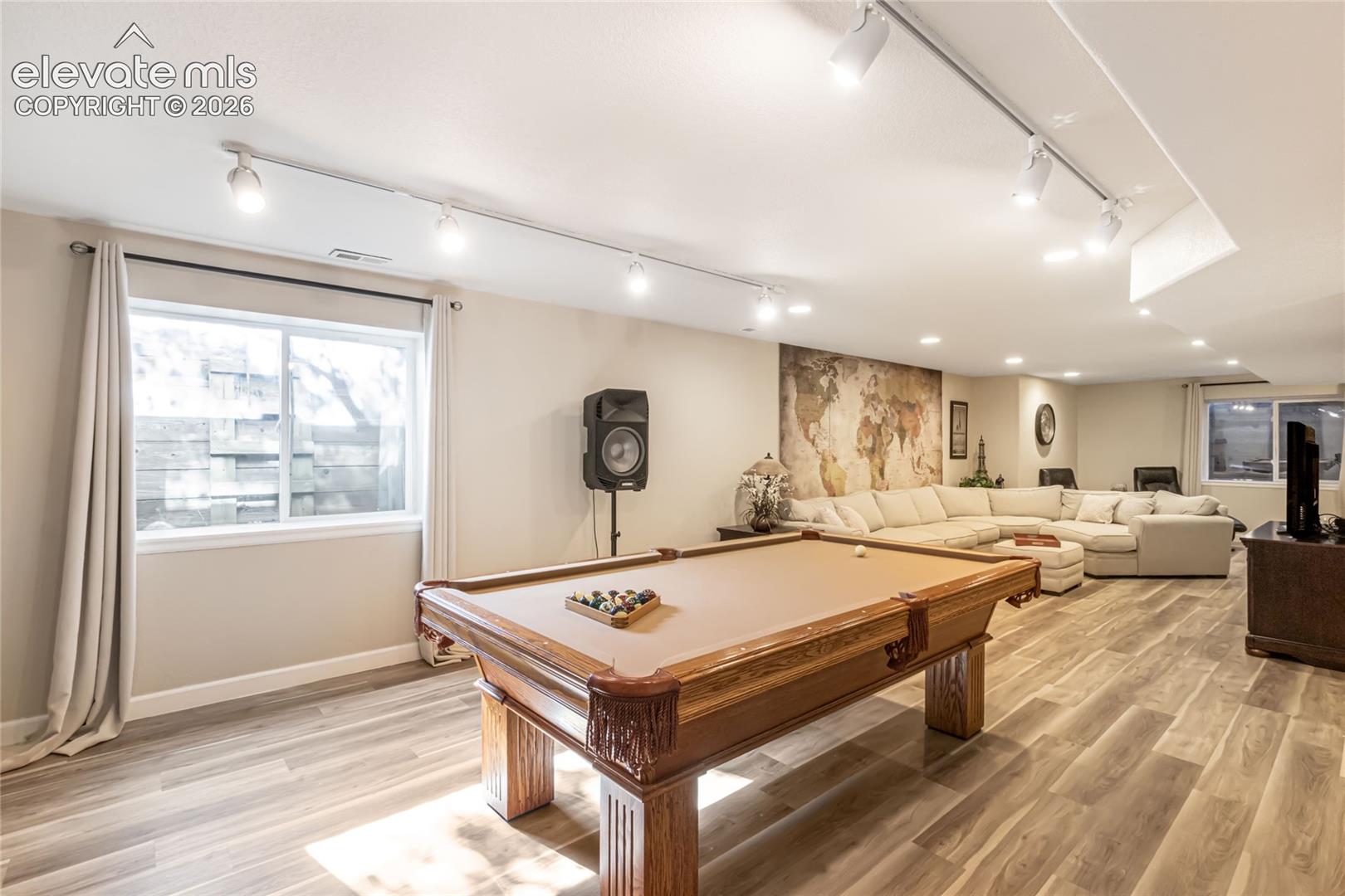 Open-concept interior featuring wood-finish flooring, adjustable track lighting, and recessed ceiling lights