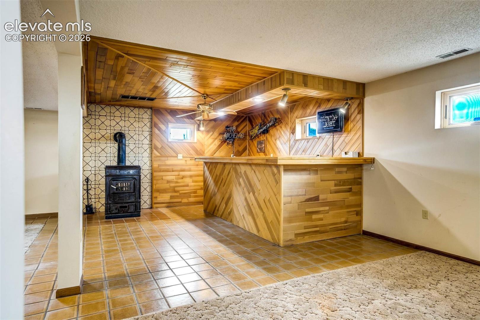  wet bar, wood burning ceramic stove, tiled flooring