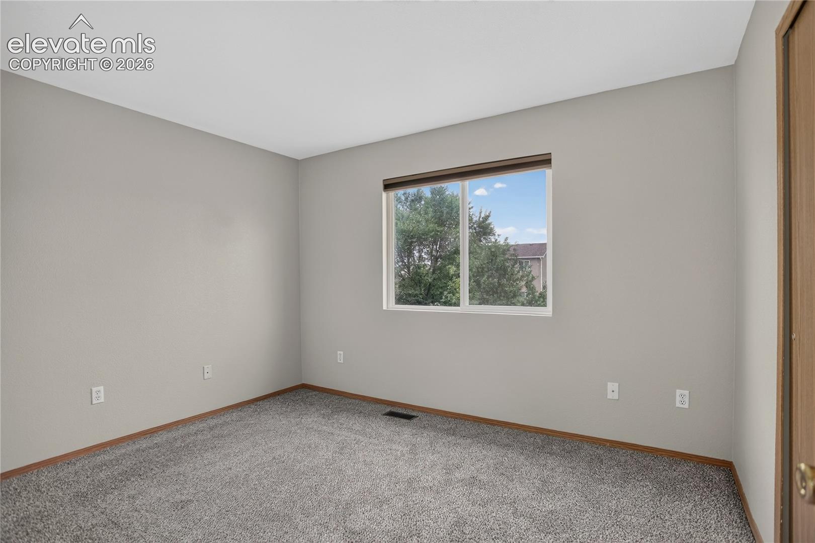Carpeted flooring with a window offering natural illumination