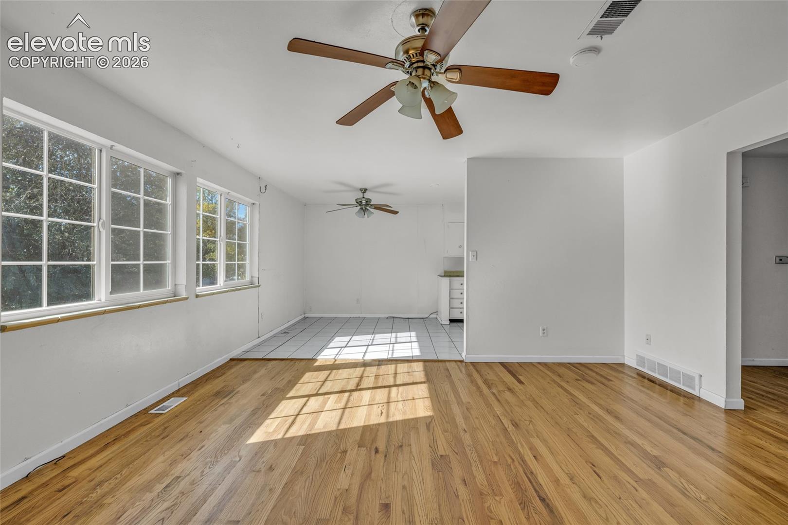 Hardwood flooring, multiple windows, ceiling fans, recessed wall opening, tile flooring
